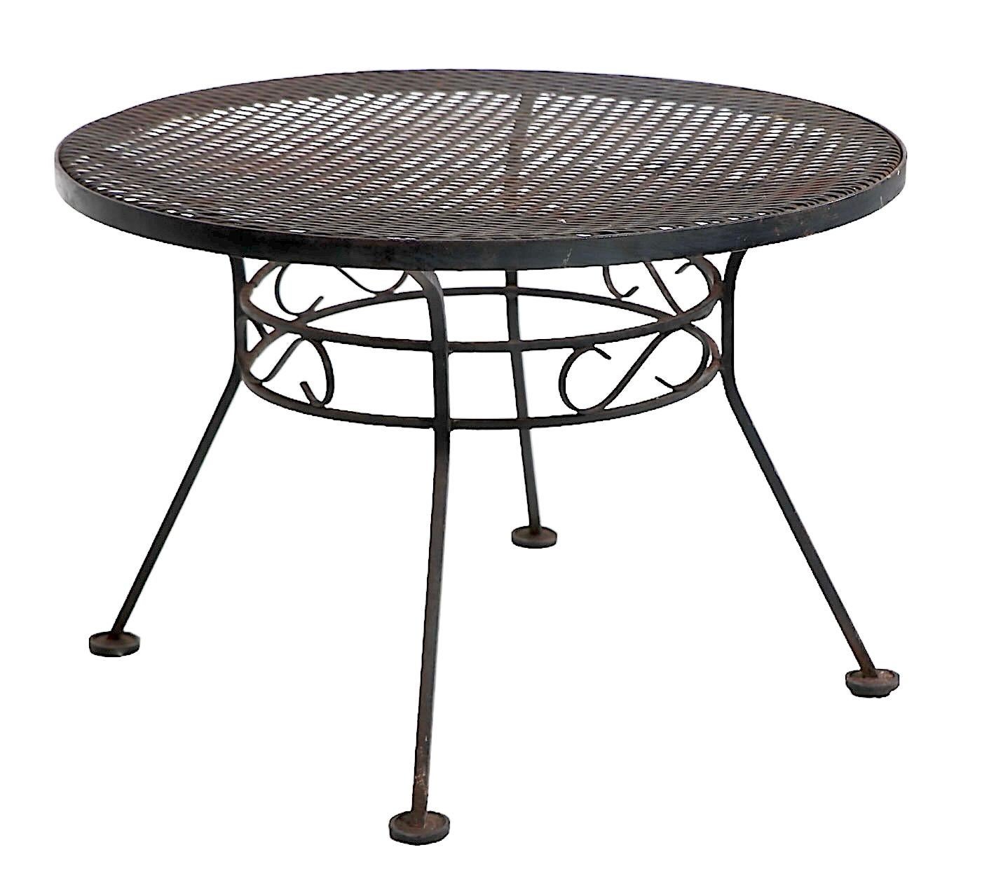 Diminutive wrought iron, metal mesh side table by Woodard Furniture, circa 1940/60's. The table is in very good, clean, original and ready to use condition, showing only light cosmetic wear,  normal and consistent with age. 
 Please view our entire