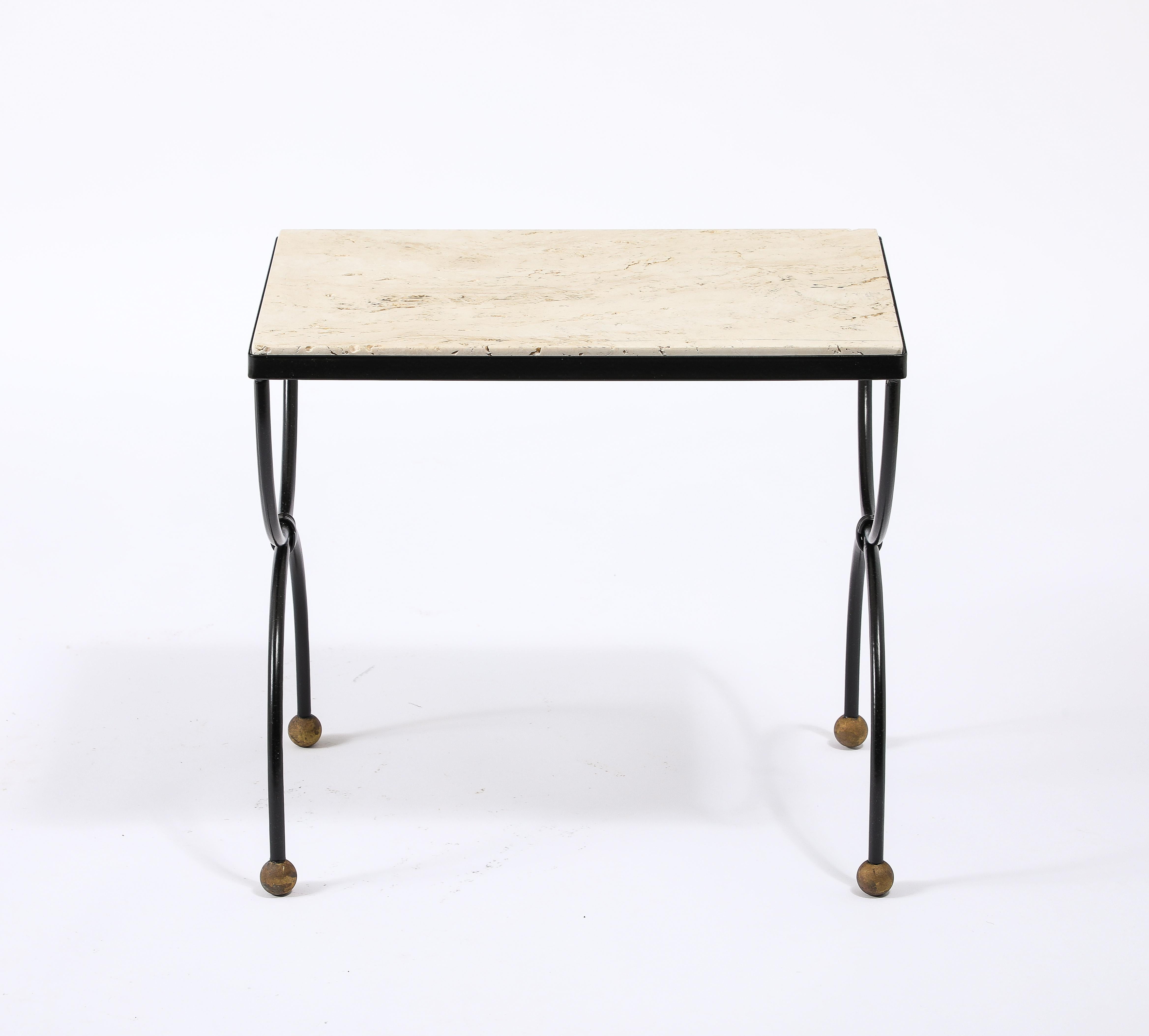 Black enameled steel end table with brass feet and a travertine top.
