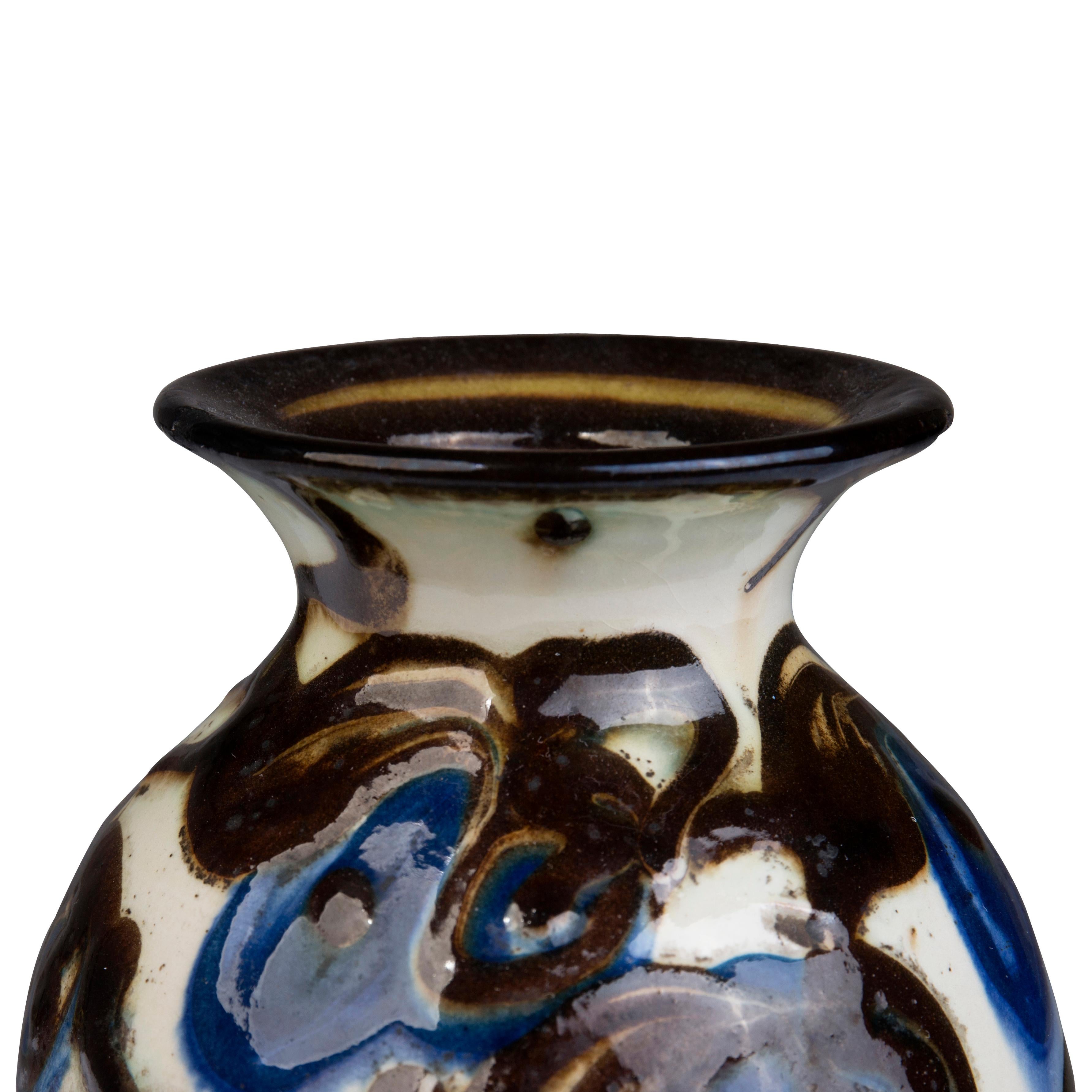 This smaller earthenware vase by Herman A. Kähler is horn-decorated with blue flowers on a light base. 

When Herman H. C. Kähler took over the family company in 1917 as the third generation of Kähler leadership, he reintroduced horn painting. This