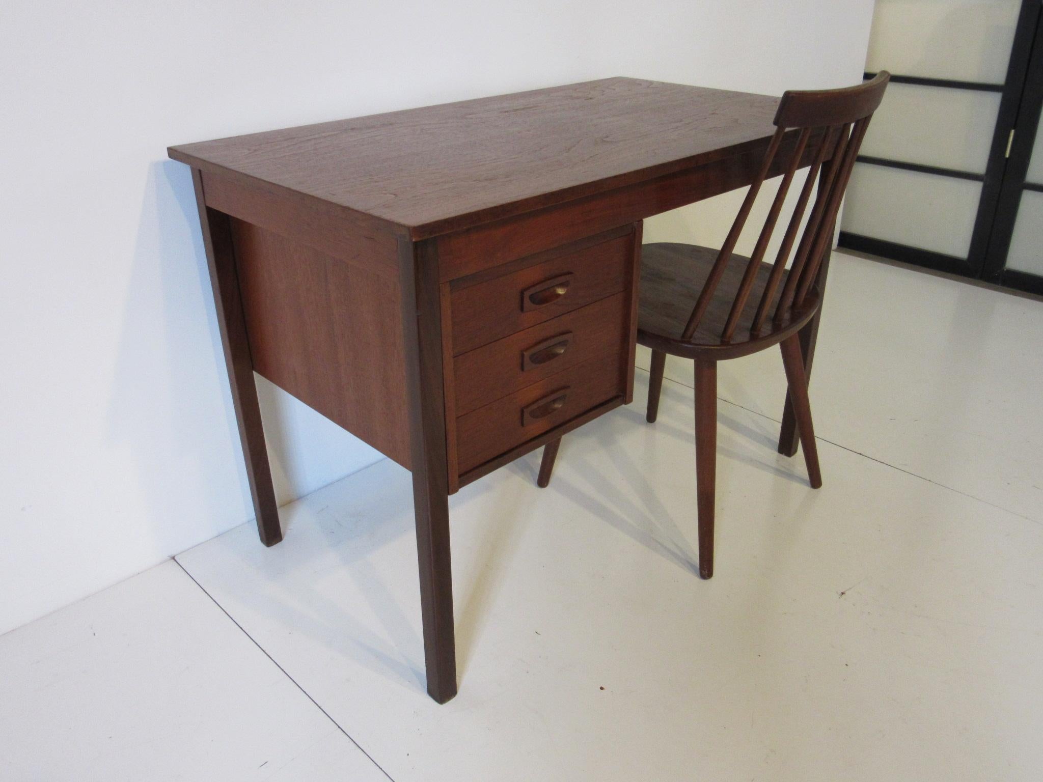 A smaller scale Kids teak wood desk with three drawers and a matching chair in the manner of Karl-Erik Ekselius, manufactured in Denmark. The chair measurement is 31.5
