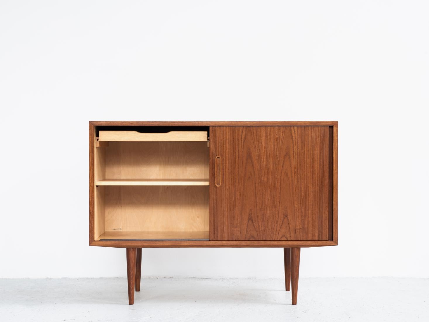 This midcentury cupboard is designed and manufactured by Hundevad in Denmark in the 1960s. True high quality manufacturing in teak. Logo stamped by manufacturer in the back. The sideboard is in very good condition.