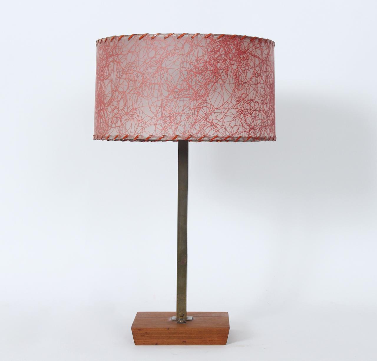 Arts & Crafts style Petite Nessen Studios Brass and Walnut Table Lamp. Featuring a square patinated Brass tubular column, atop a square Walnut topped weighted Iron base. Base switch. Leviton Brass double sockets. 17H to top of sockets. Lamp shade