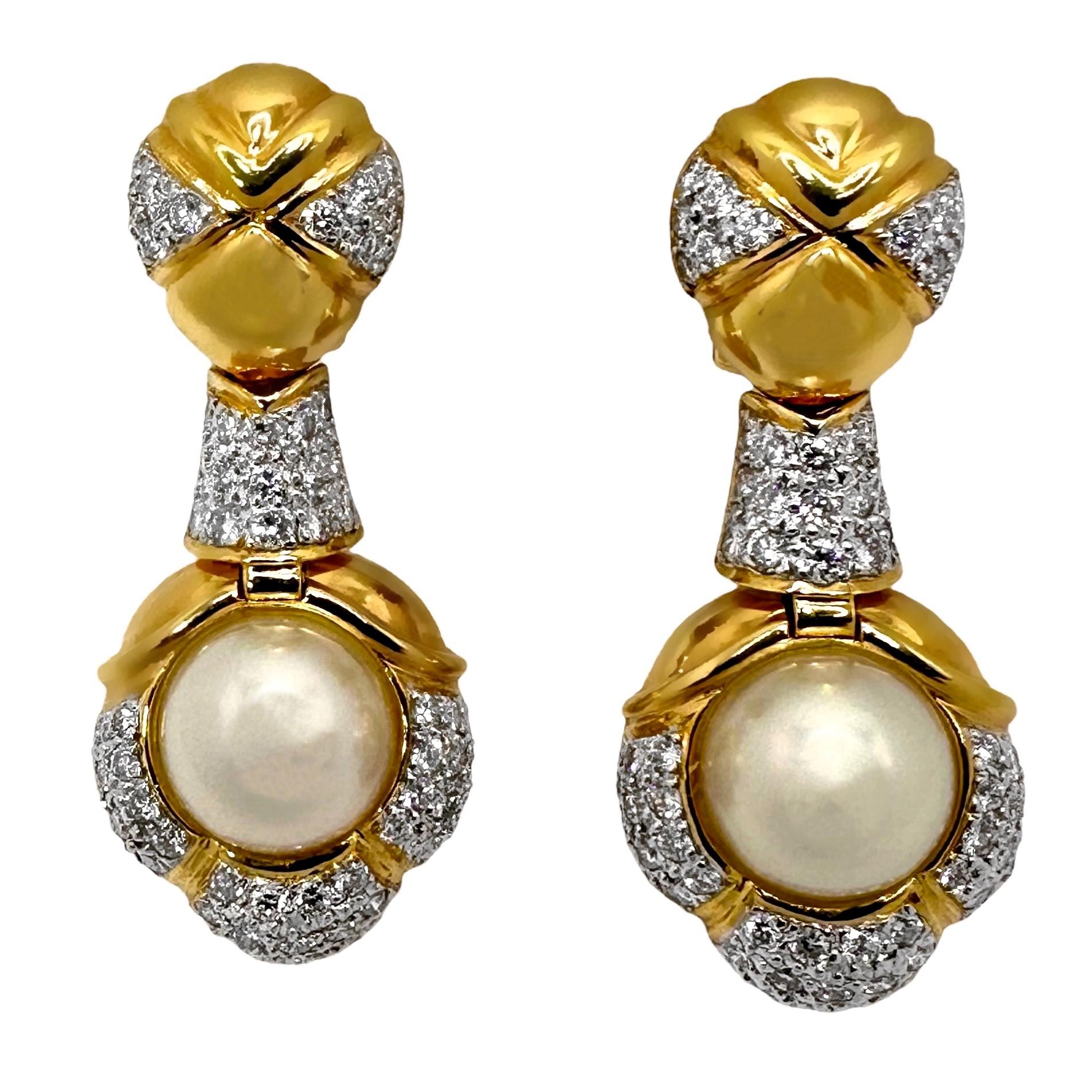 Fashioned in 18k yellow gold, these handsome earrings are set with two 9.5mm cultured pearls adorned with high quality brilliant cut diamonds.
Total diamond weight is 1.91ct of overall G/H color and VS1 clarity. 
Measures 1 3/4 inches long by 5/8