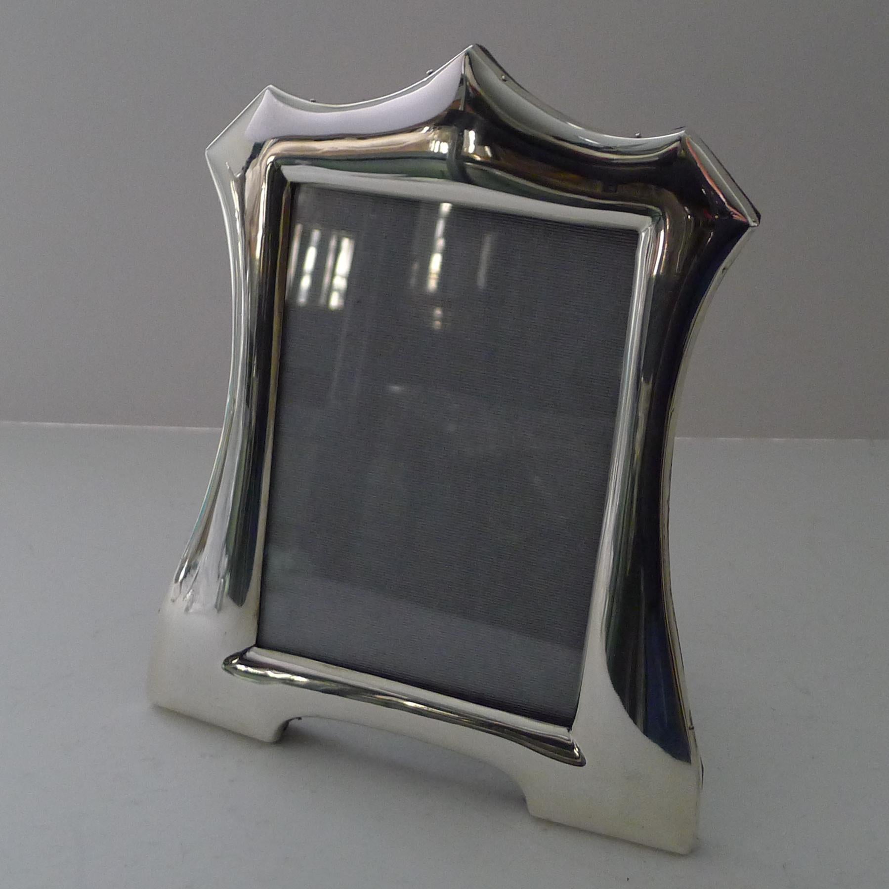 A very elegant English silver picture frame, a lovely shape fully hallmarked for Birmingham 1913 together with the makers mark for the well renowned silversmith, Walker and Hall.

The back has a solid English Oak backing incorporating a folding