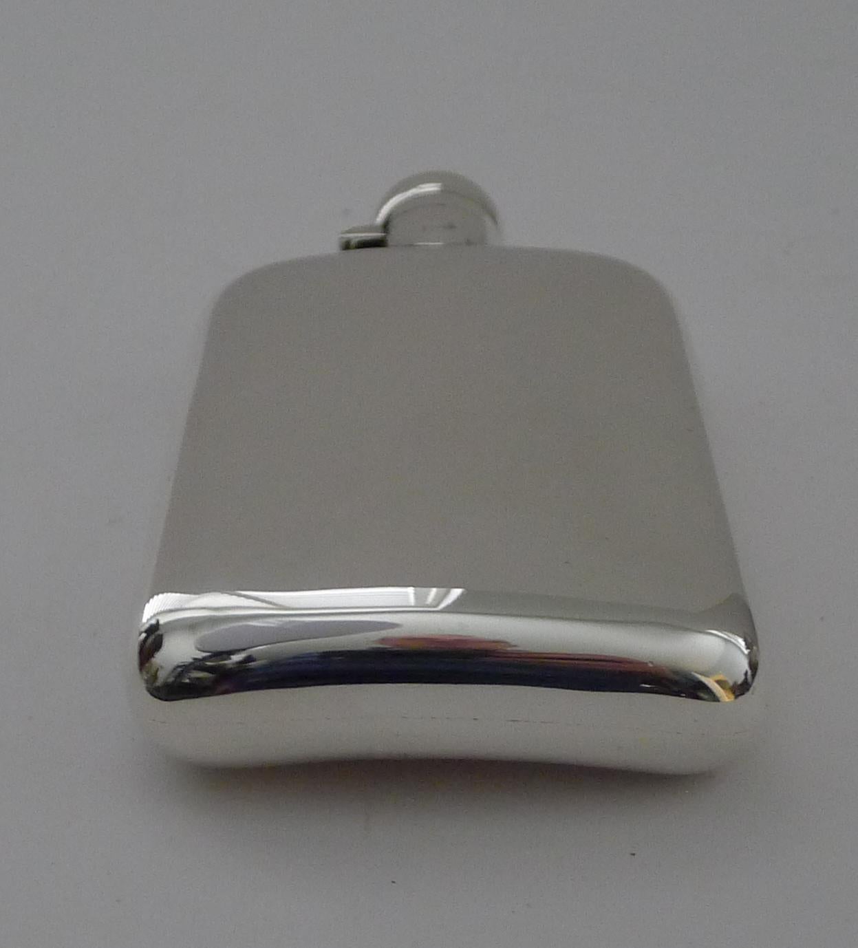 A very smart antique English solid / sterling silver hip flask / spirit flask.  Shaped to fit neatly into a pocket with it's shaped back.

The top has a bayonet fitting requiring a turn and lift movement to open, the interior of the lid retaining