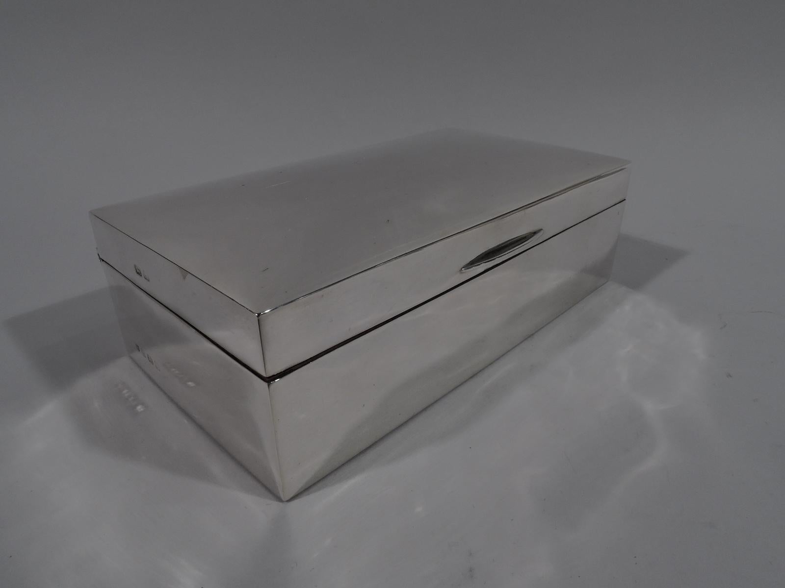 George V sterling silver box. Made by Charles S. Green & Co., Ltd in Birmingham in 1925. Rectangular with straight sides. Cover hinged, tabbed, and gently curved. Box and cover interior cedar lined and partitioned. Box underside leather lined. Smart