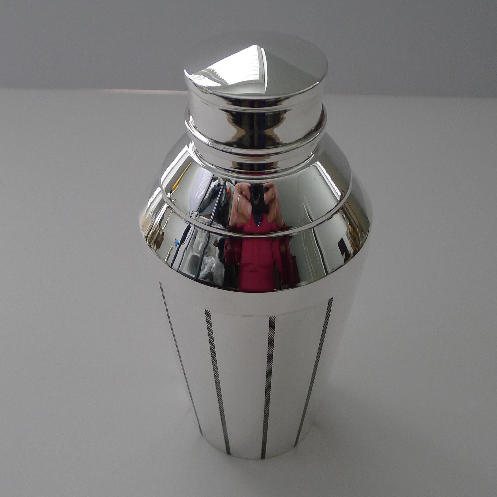 A striking and very unusual cocktail shaker in silver plate dating to c.1940.

Just back from our silversmiths workshop where it has been professionally cleaned and polished, restoring it to it's former glory.

The body is smartly decorated with