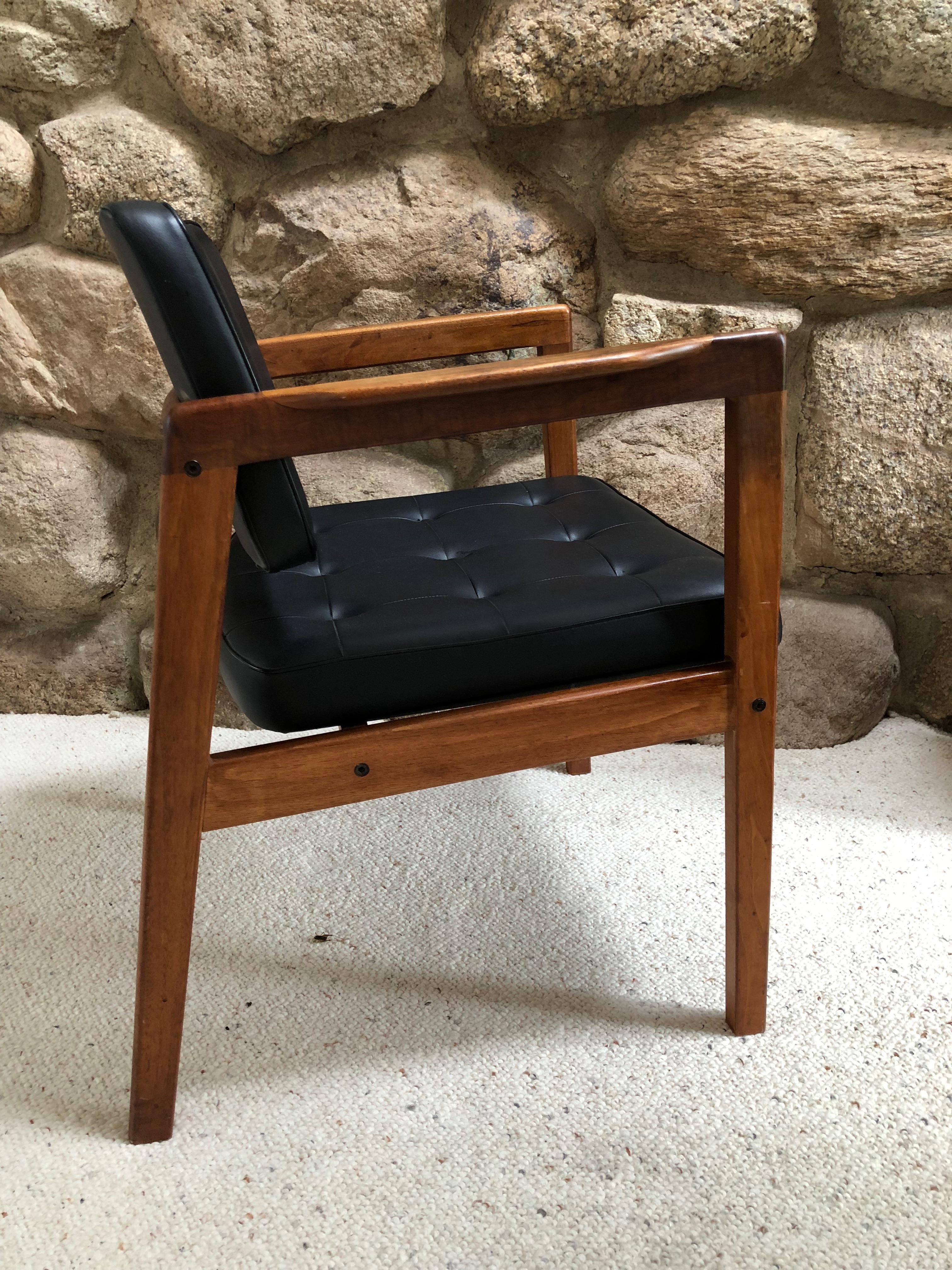 Handsome Danish Modern midcentury armchair by Illum Wikkelso for Niels Eilersen. Made of solid teak wood and upholstered in the original black faux leather. Measures: Arm height 26.