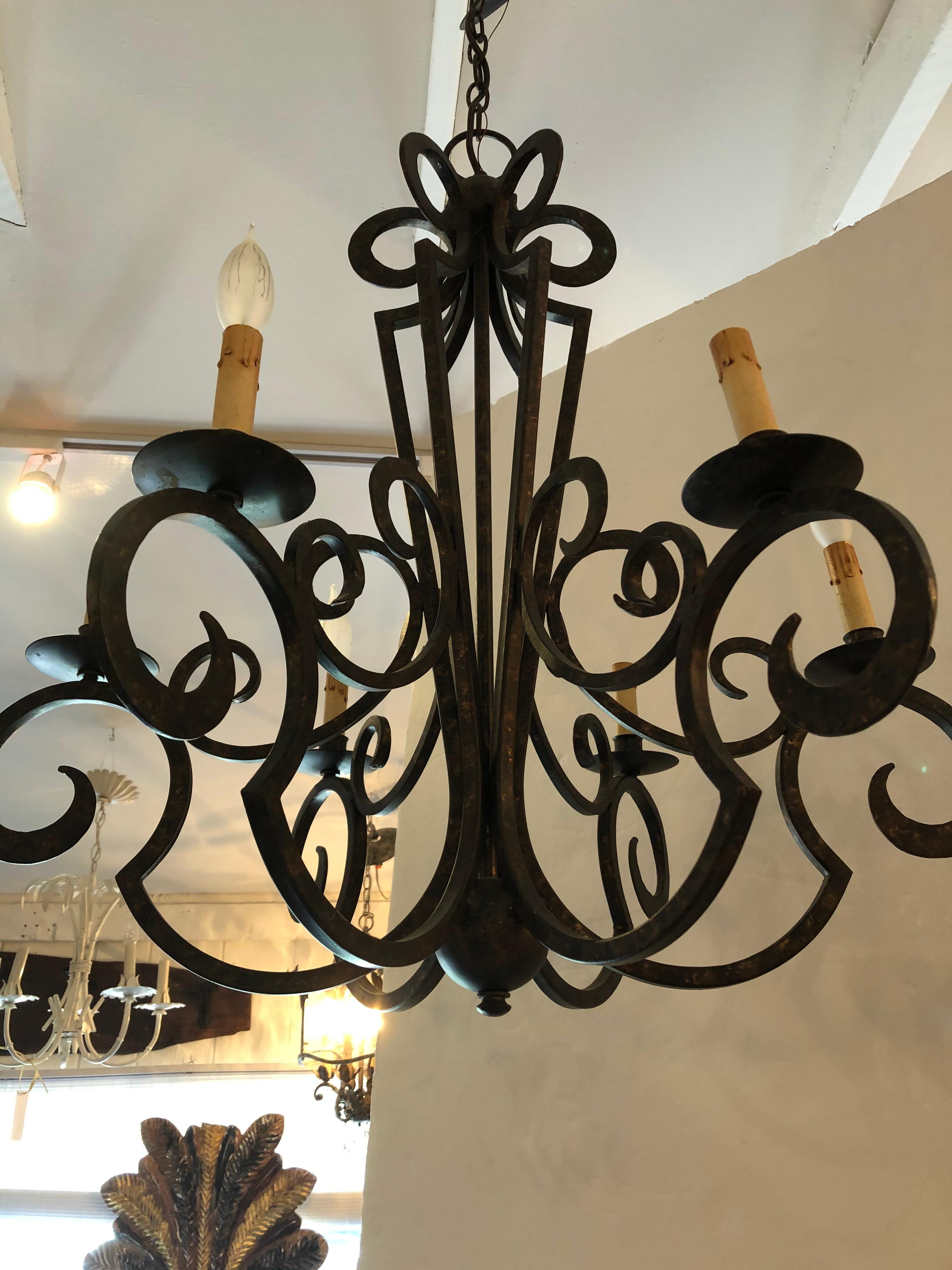 A great looking stylish wrought iron curlicue contemporary chandelier having a fabulous dark bronze finish with traces of gilding underneath. Nice size with 6 arms and matching ceiling cap as well as 16