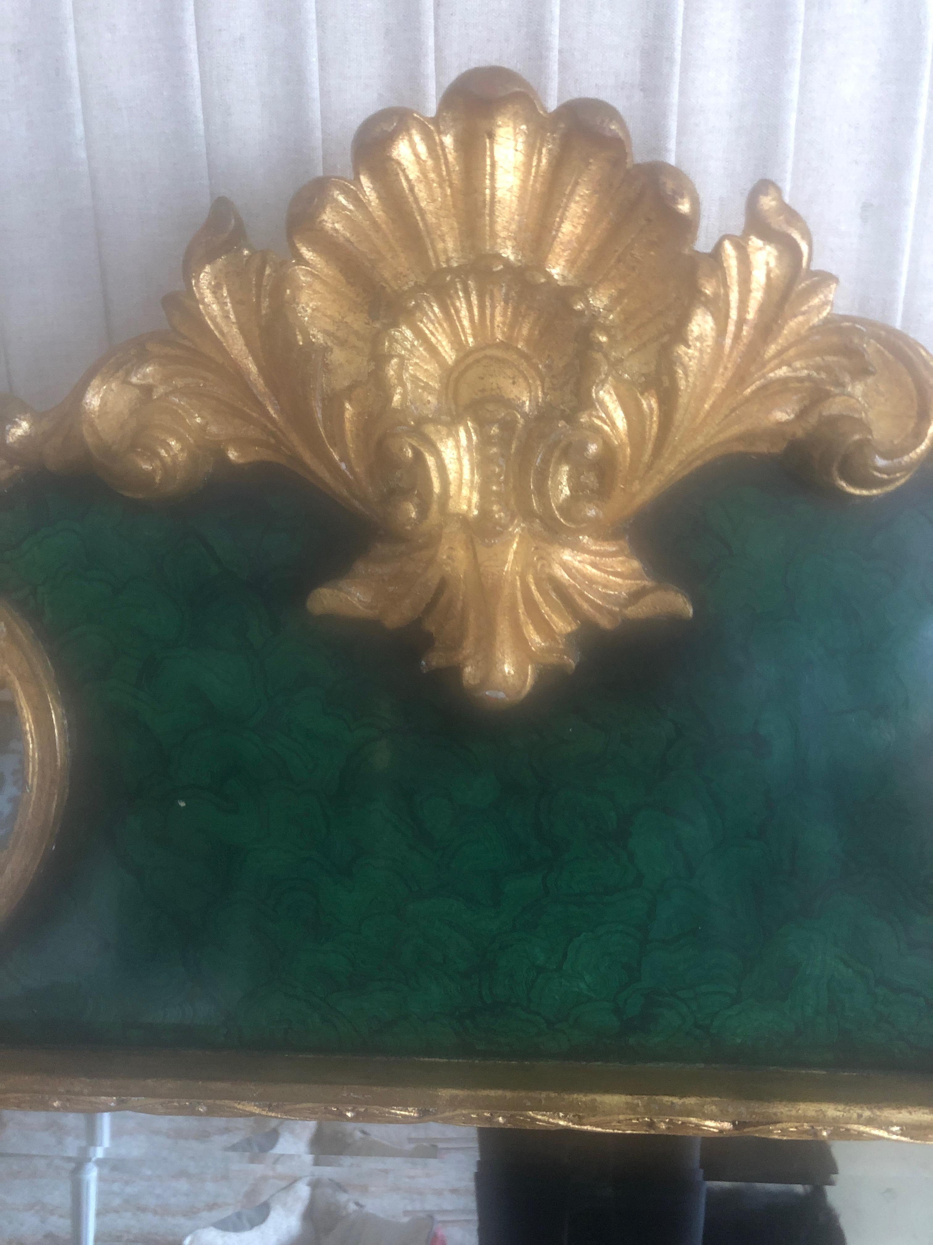 Eye-catching elegant French style mirror having a faux malachite frame in a gorgeous shade of green with glistening gilded details.