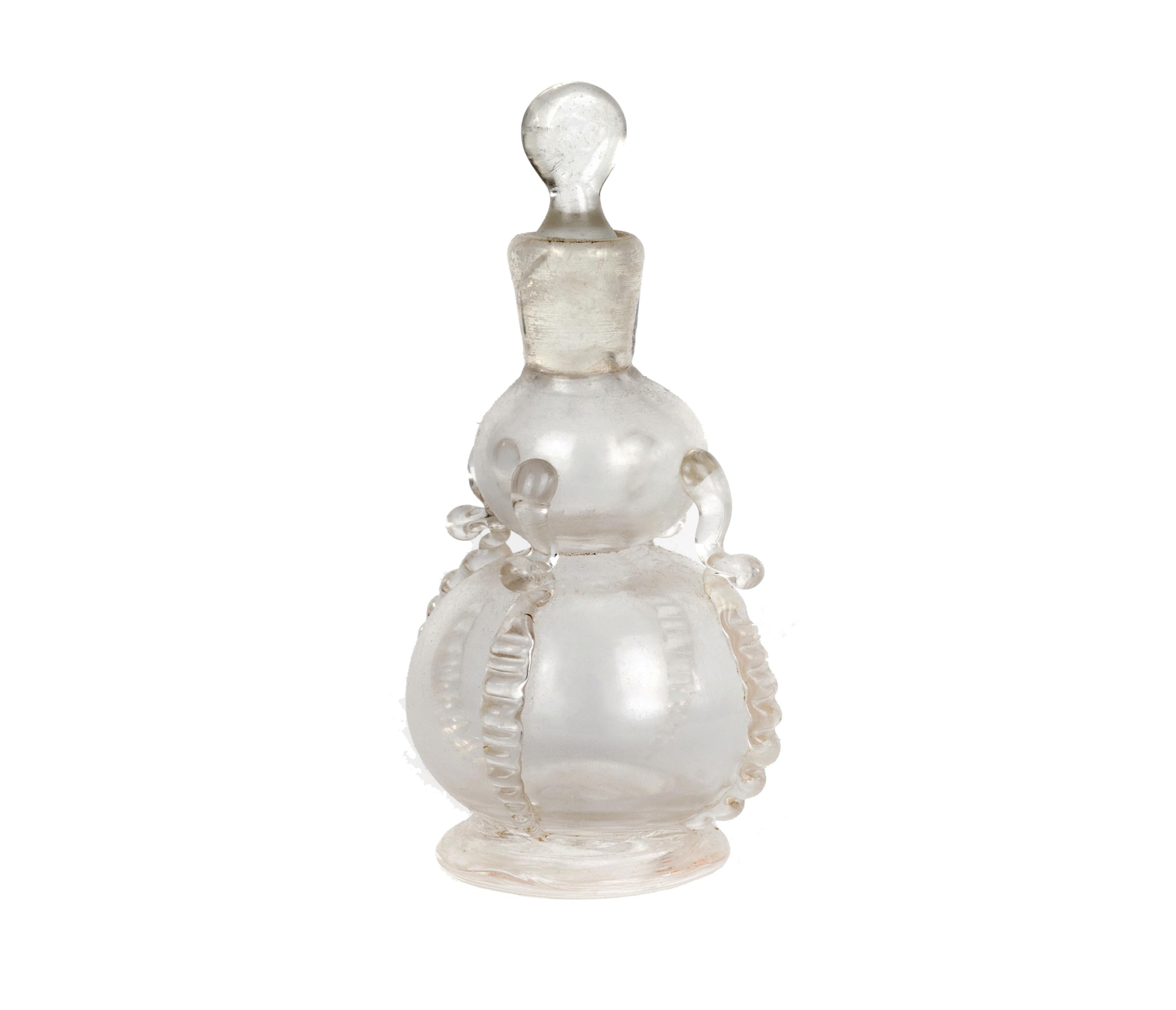 An early colorless smelling bottle or scent adorned with ribbons, rigaree and pontil mark, early 20th century