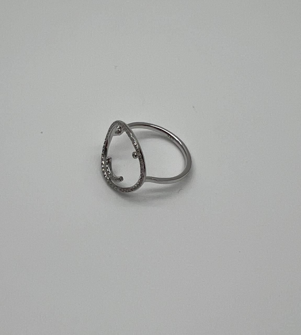 This striking piece features a playful smiley face design. The face is crafted with a circle of sparkling diamonds, forming the eyes and mouth, set in a sleek 14K White Gold band. The open design allows light to pass through, enhancing the
