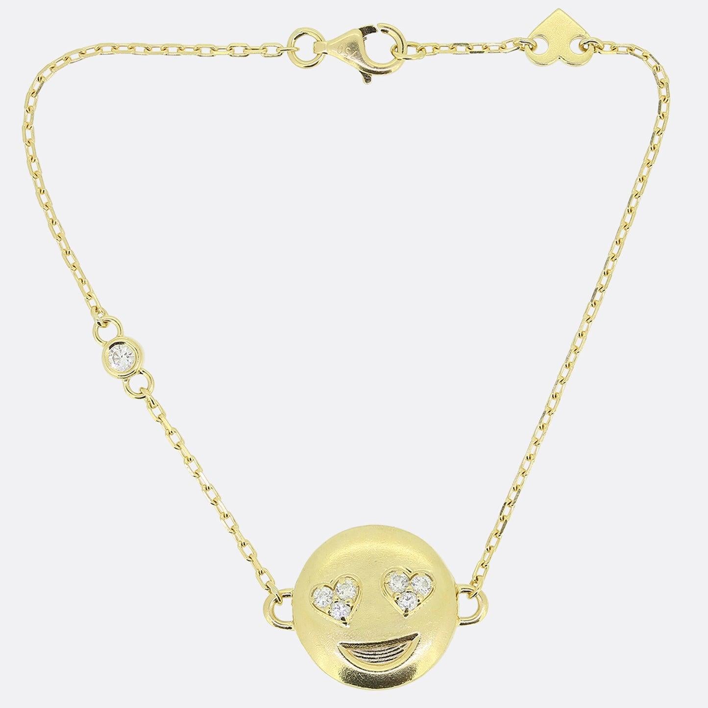 Aquí tenemos una encantadora pulsera de cadena de diamantes. Esta pieza ha sido elaborada en oro amarillo de 18 ct y luce un diseño de carita sonriente. Este motivo focal se ha engastado con ojos engastados con diamantes en forma de corazón de amor