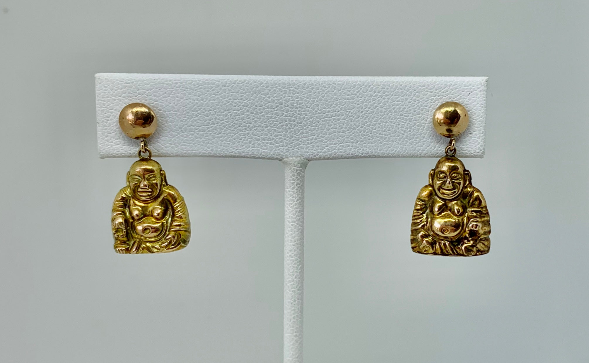 This is a wonderful pair of antique Smiling Happy Buddha Dangle Drop Earrings in 14 Karat Gold.  The wonderful earrings have two wonderful gold Buddhas.  The Buddhas are fully three dimensional.  The Buddhas have beautiful smiling faces and round
