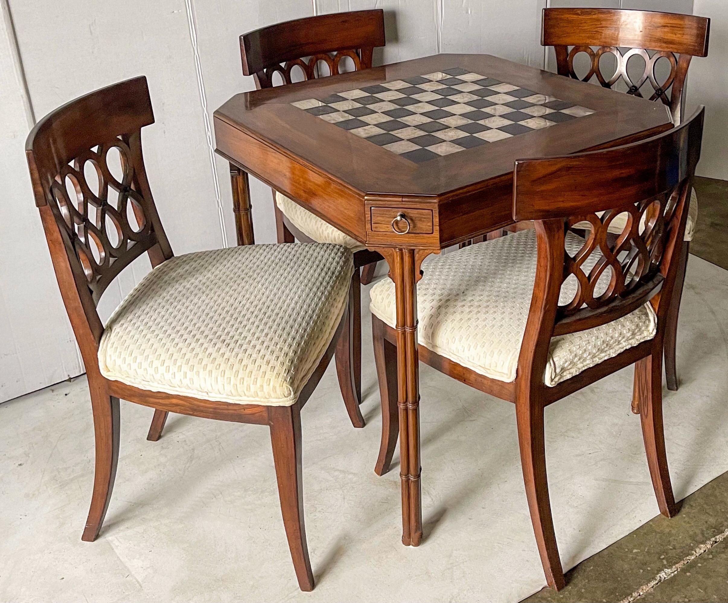 This is an incredible set! It is a Smith and Watson regency style game table and chairs. It was a privately commissioned set. The squares and pieces are silver plated. The carved mahogany faux bamboo table has drawers at each corner as well as two