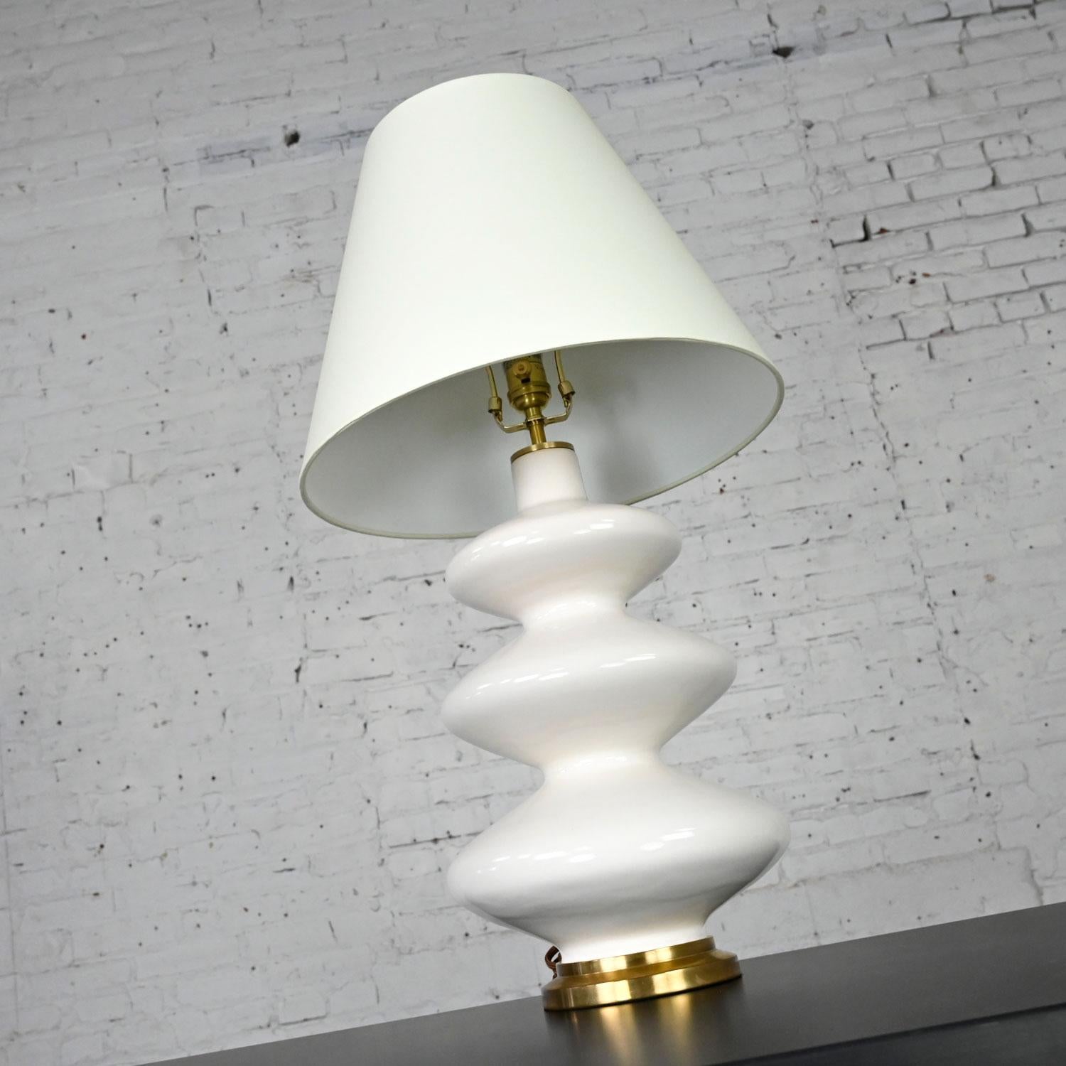 Gorgeous Smith ivory table lamp by Christopher Spitzmiller for Visual Comfort. Comprised of an ivory ceramic lamp body with living finish and featuring a brass check ring, brass socket, brass ball finial, and brass base with its original natural