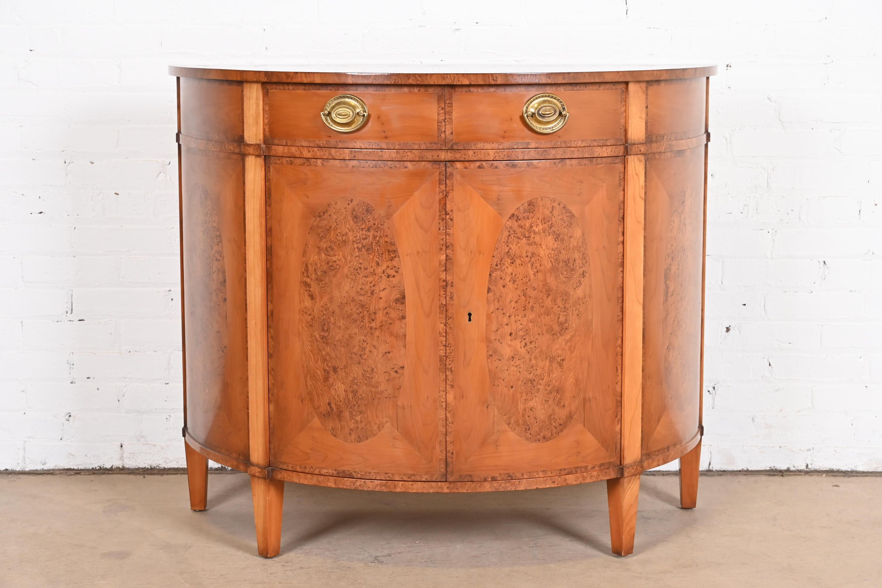 A gorgeous English Georgian or Federal style demilune sideboard, bar cabinet, or console table

By Smith & Watson

New York, USA, Late 20th century

Stunning inlaid burl wood and yew wood, with original brass hardware. Cabinet locks, and key