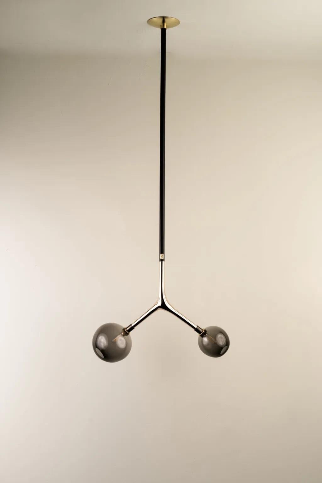 Smoke Dupla Pendant Lamp by Isabel Moncada
Dimensions: W 45 x D 20 x H 125 cm.
Materials: Brass, cast bronze and blown glass.

Dupla hangs from the ceiling just like a branch with its fruits. The customizable length options allow play with scale and