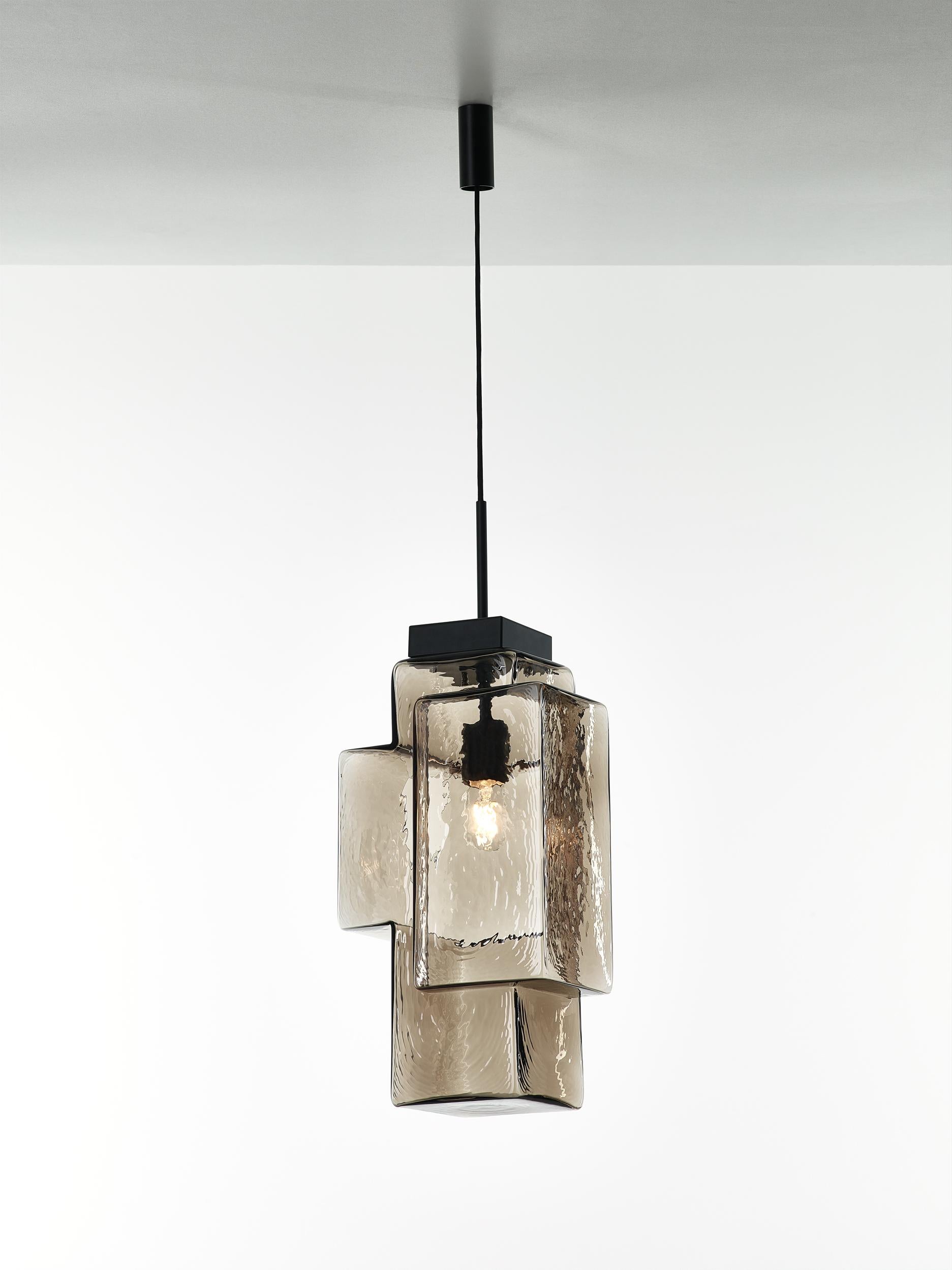 Smoke grey Tetris pendant light by Dechem Studio.
Dimensions: W 30 x D 23 x H 200 cm.
Materials: metal, glass.
Also available: different colours available.
In this complex lighting fixture, strict geometric and architectural lines contrast with