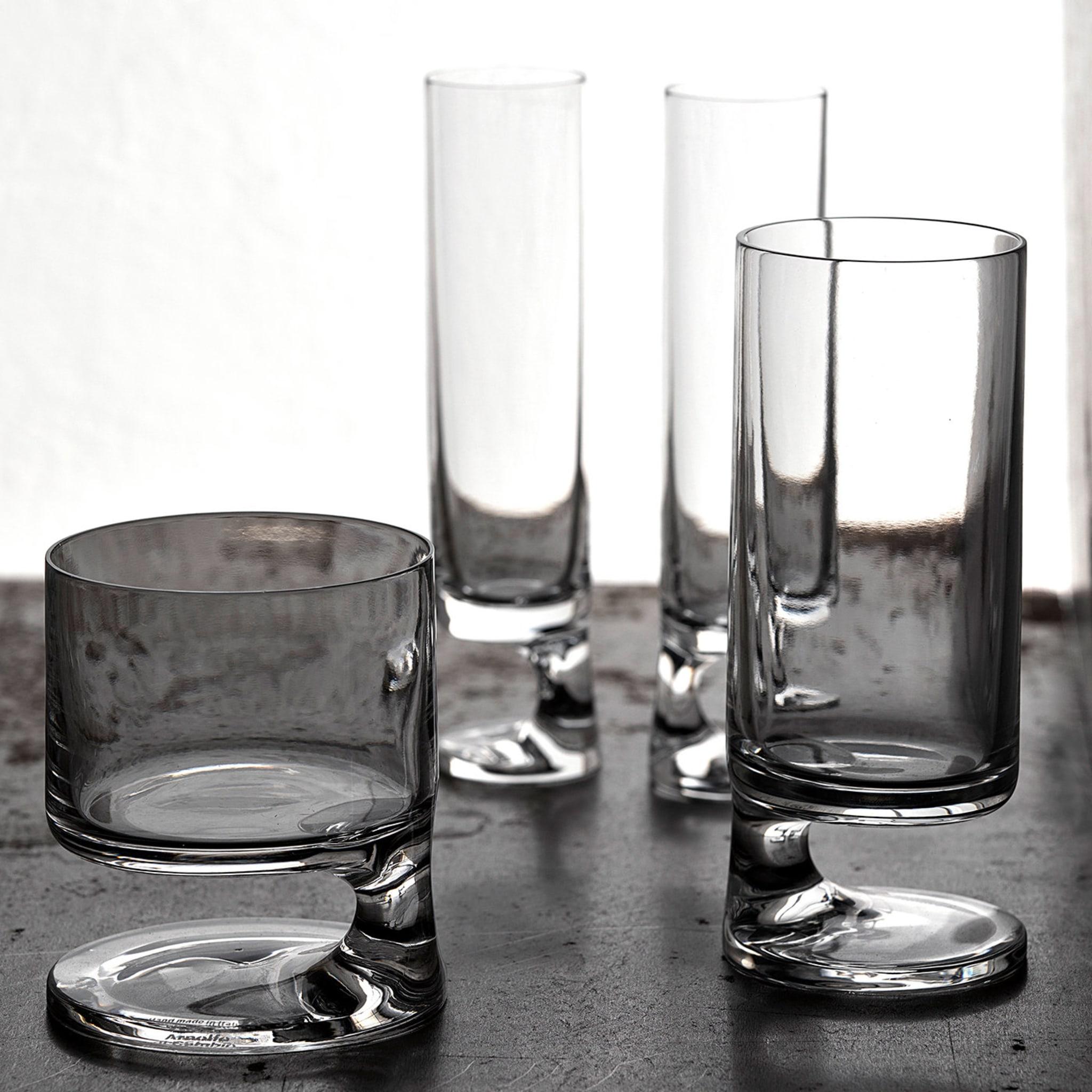 Sophisticated and surprising, this set of two champagne glasses will be an eye-catching addition to a contemporary interior and will captivate the imagination with its unique silhouette. Crafted of handmade mouth-blown crystal, these two glasses are