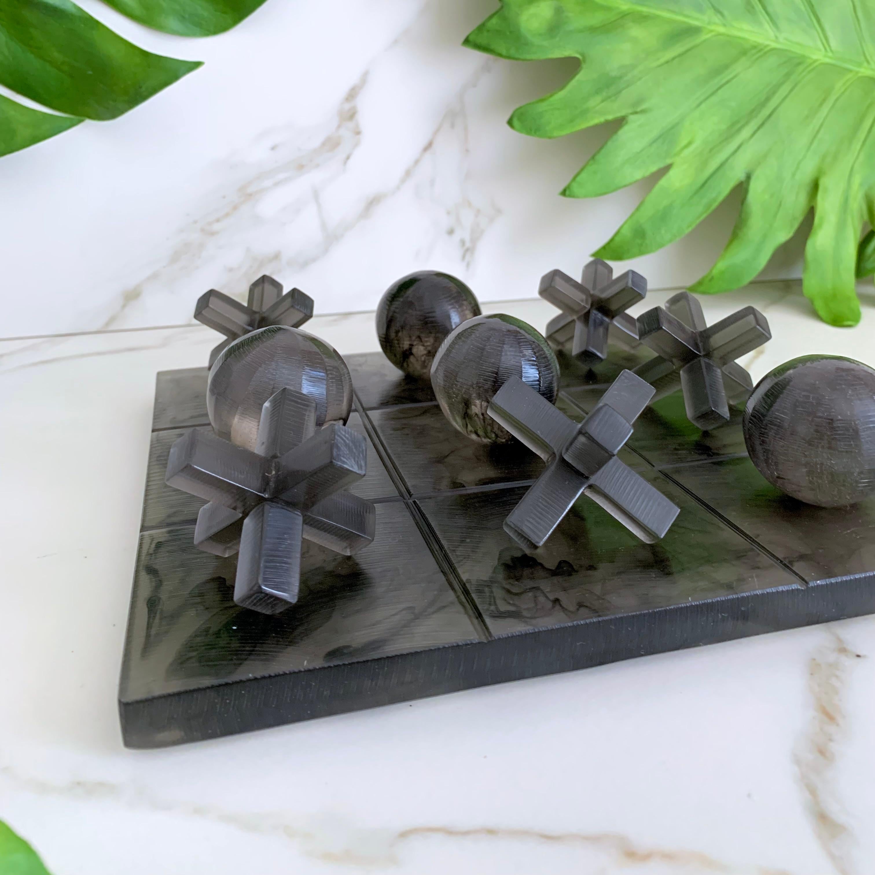 Our Tic Tac Toe is a beautiful, modern and fun take on the classic game. The three dimensional pieces and board are handmade in smoke resin with black marbled texture. It will be the coolest statement piece on any coffee table.

Materials: Resin