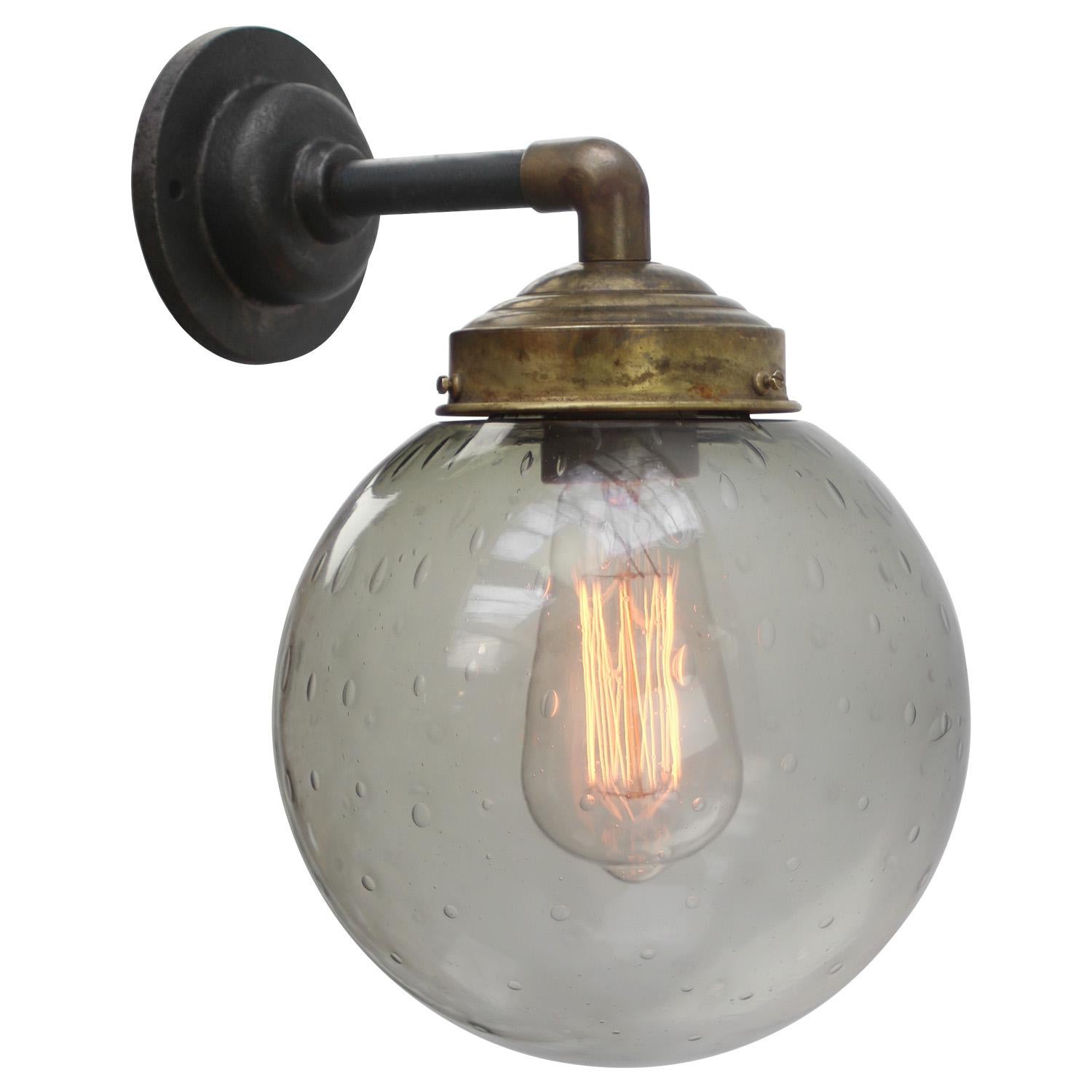 Brass and cast Iron Industrial wall light
smoked air bubble glass globe

Diameter cast iron wall piece: 10.5 cm / 4”, 2 holes to secure

Weight: 2.50 kg / 5.5 lb

Priced per individual item. All lamps have been made suitable by international