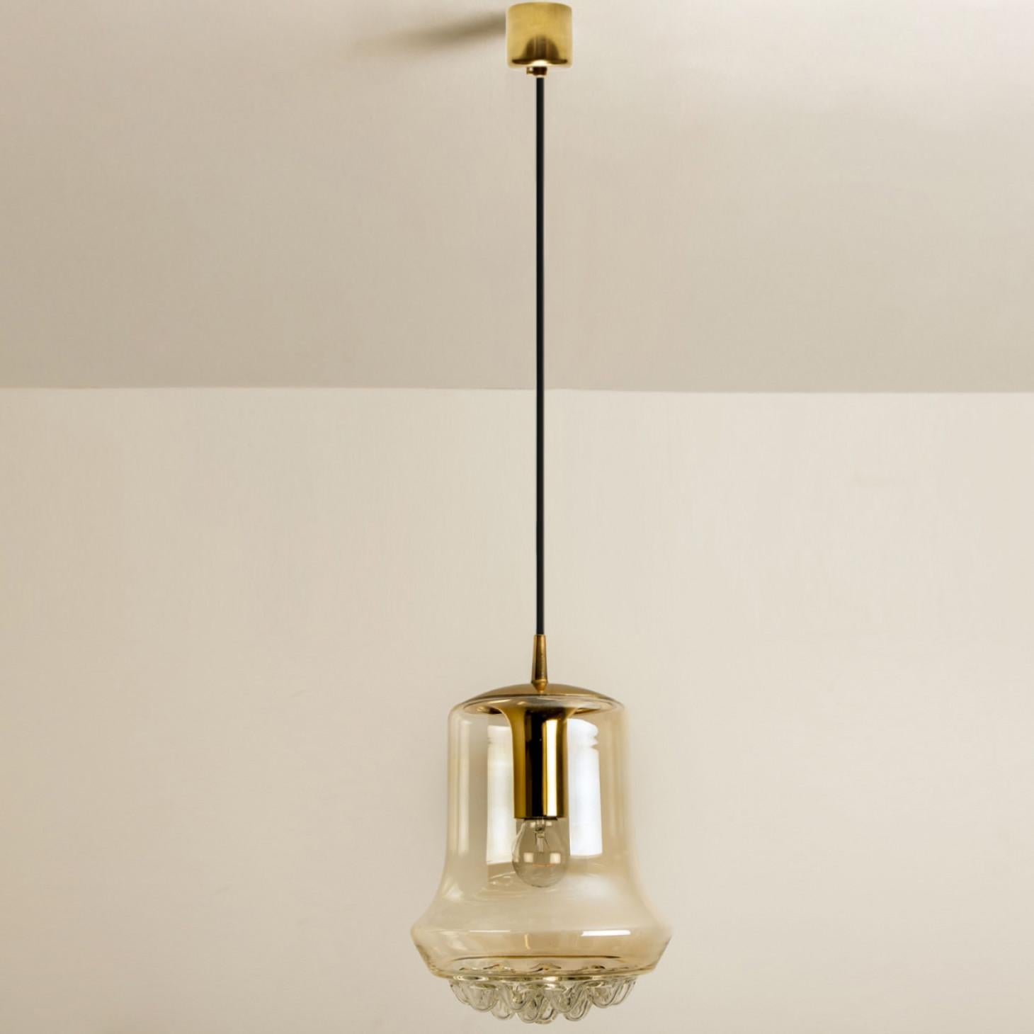 Smoked golden/brown pendant lights, 1960s by Peill and Putzler in Germany, Europe. A unique shape and a wonderful light effect due to lovely glass elements. High quality pieces. Illuminates beautiful. True craftsmanship of the 20th century.

We also