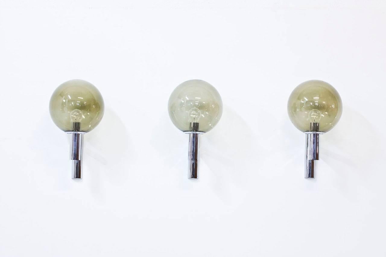 Set of three wall lamps in chrome-plated steel with smoked glass lamp shades. Made in Italy during the 1960s.