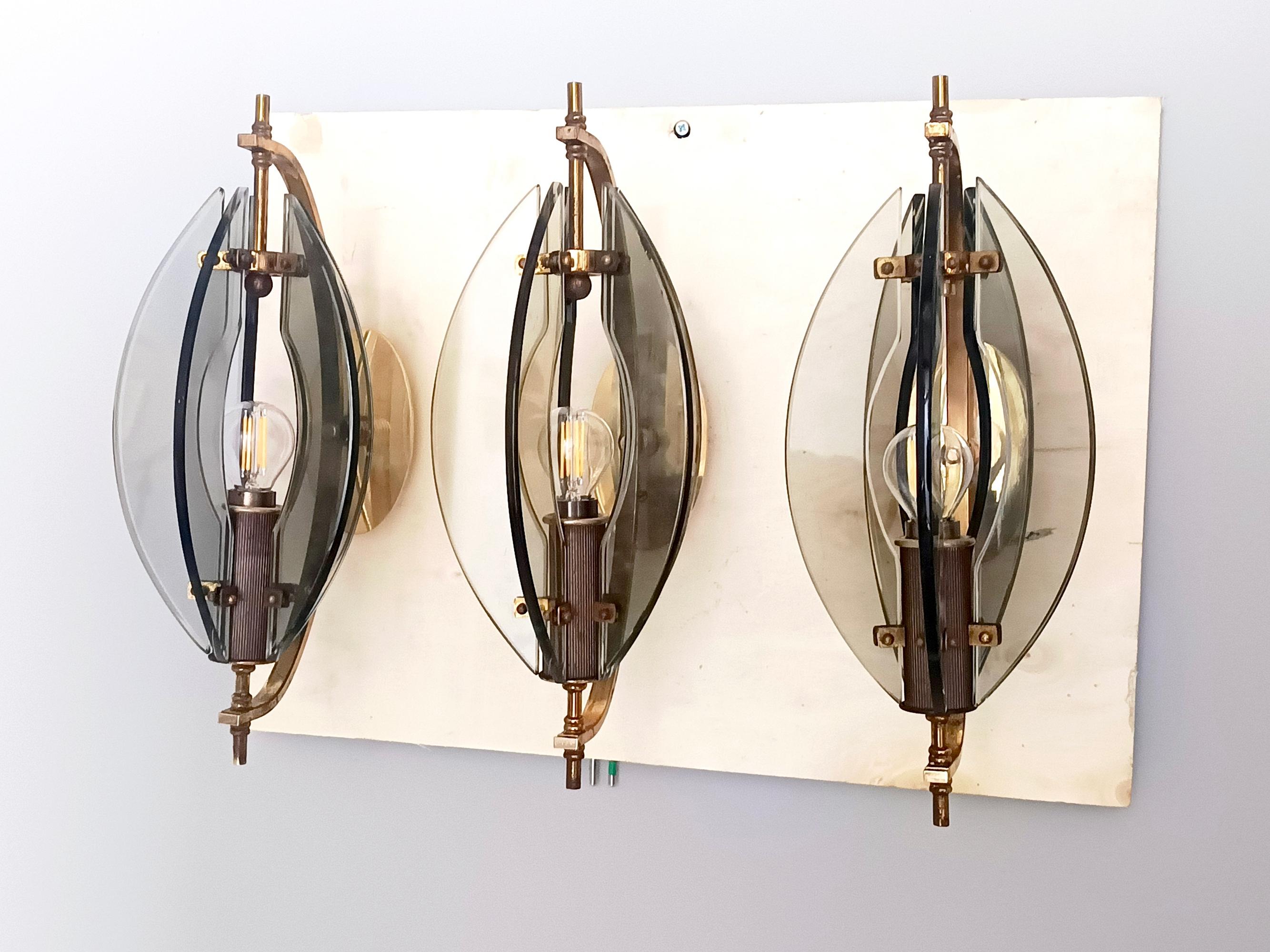 Fabricado en Italia, años 60. 
Estos elegantes están fabricados en latón y cristal transparente y ahumado. 
Se ha inspeccionado su cableado y es compatible con EEUU.
Se trata de apliques vintage, por lo que pueden mostrar ligeras huellas de uso,
