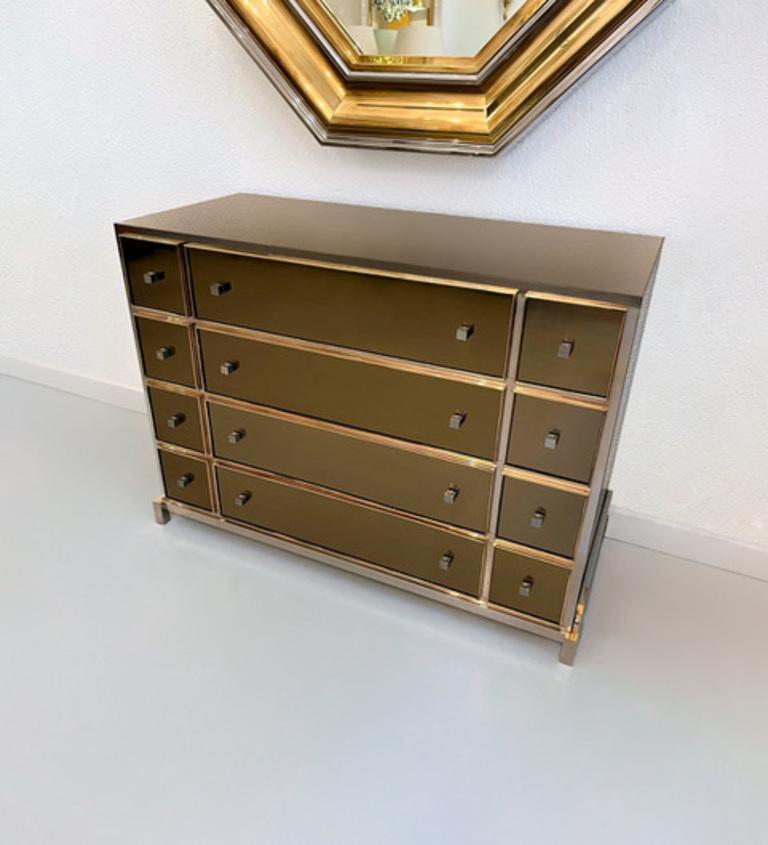 High quality and exquisite smoked mirrored, brass and chrome dresser by Michel Pigneres, France ca. 1970s
12 smoked glass drawers with brass frame and finished with brown lacquer on the inside. Cube steel handles.
Chrome base.
Very good condition. A