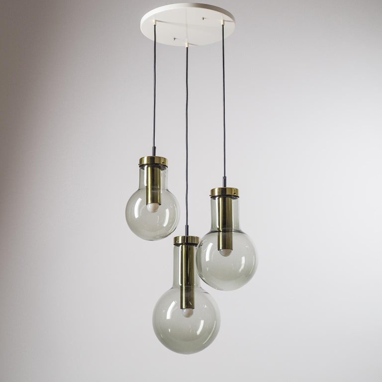 1970s cascading chandelier by RAAK, Netherlands, with three large smoked glass globe pendants in different sizes that can be adjusted individually. Very good original condition with manufacturers labels on each fixture and one original ceramic E27