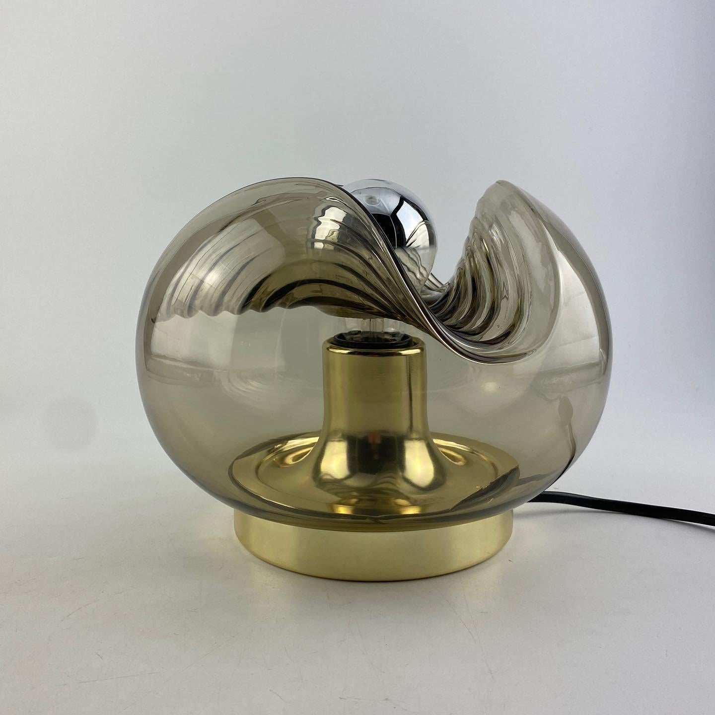 Beautiful German table light manufactured by Peill and Putzler produced around 1970. Amazing wave shaped smoked glass globe and gold chromed parts. This combination in a table lamp does not show up very often, pretty uncommon.

Has been rewarded