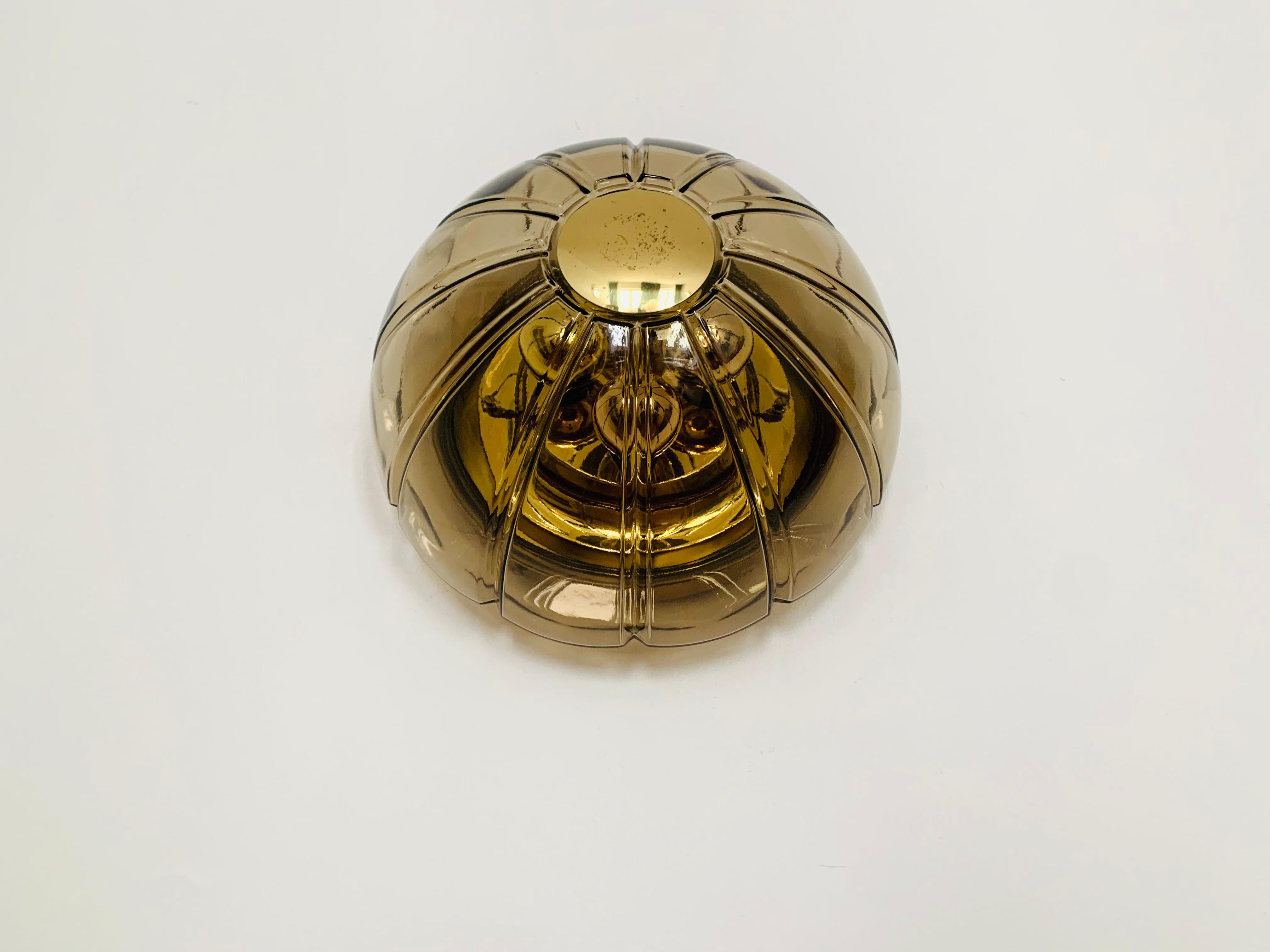 Very nice and large smoked glass and brass wall lamp or ceiling lamp from the Limburg glassworks from the 1960s.
The lamp makes a great and exciting play of light in the room and enchants with its charisma.
Wonderful design and very high quality
