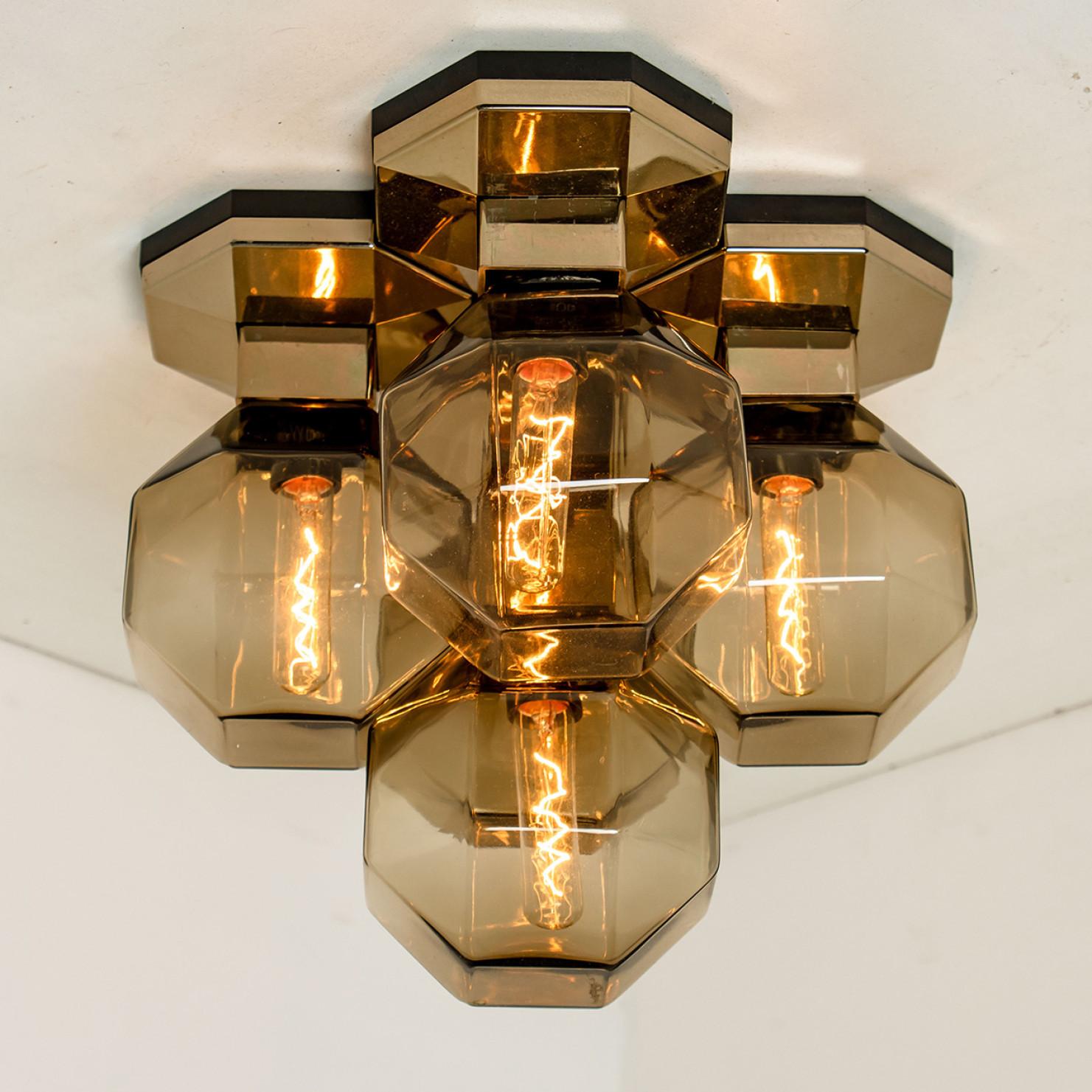 A rare wall or flush mount ceiling lamp by Motoko Ishii for Staff Lighting Company, Germany. Heat-resistant resin, metalized base and 4 smoked glass shades. Beautiful design, reflective lamps in all directions. Typical design from the 1970s. The