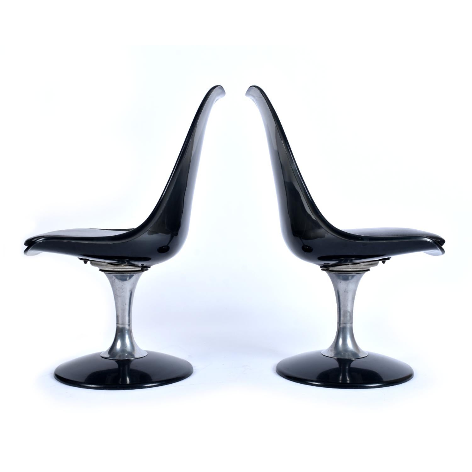 Stunning set of four smoked Lucite dining chairs by Chromcraft. The stylish chairs are formed from molded translucent black acrylic and mounted on an aluminum pedestal. The stem like pedestal terminates at a wide base, eliminating the cacophony of