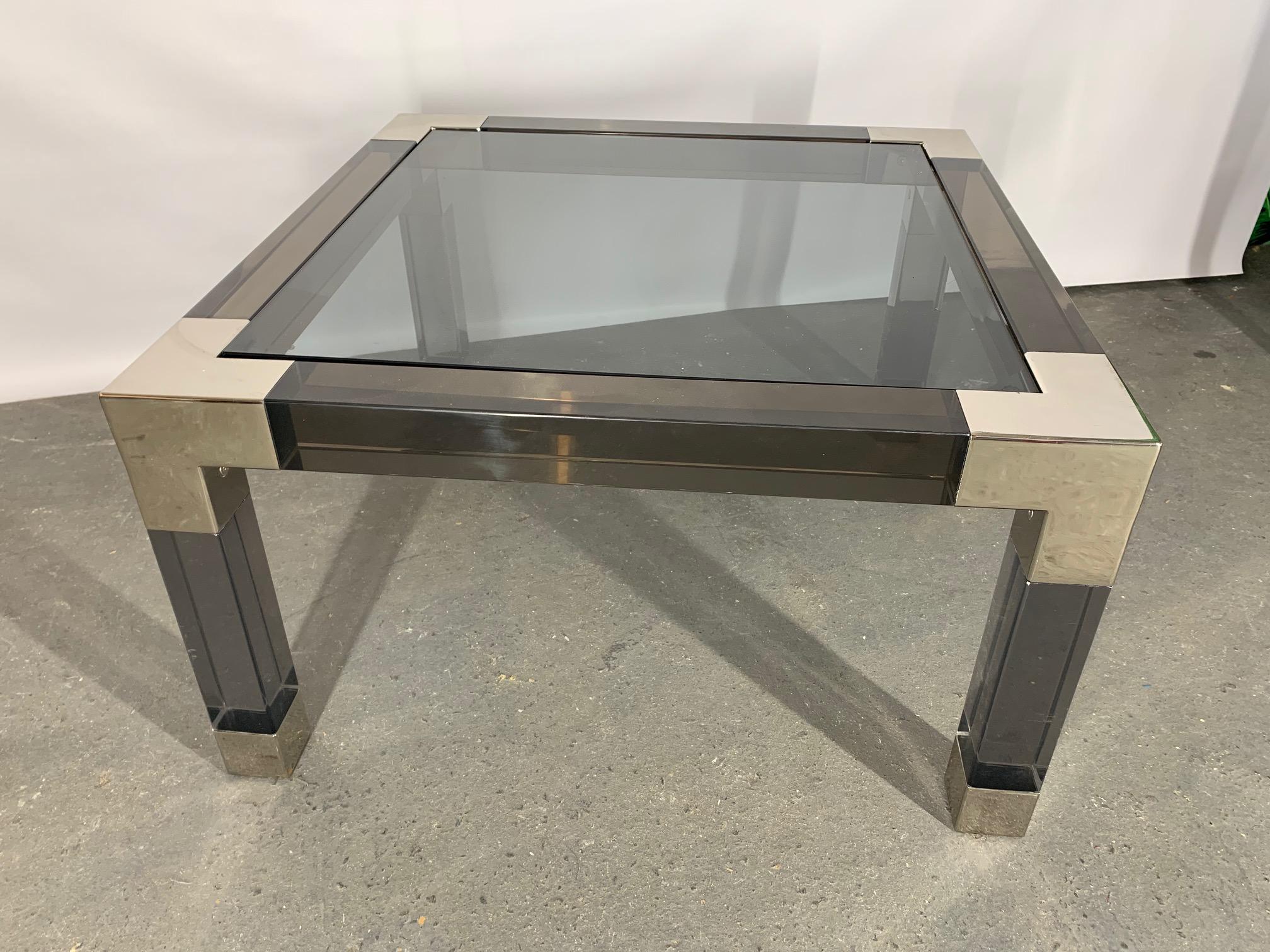 Heavy Lucite table by Jonathan Adler features chrome accents and glass top. Good condition with minor imperfections.
