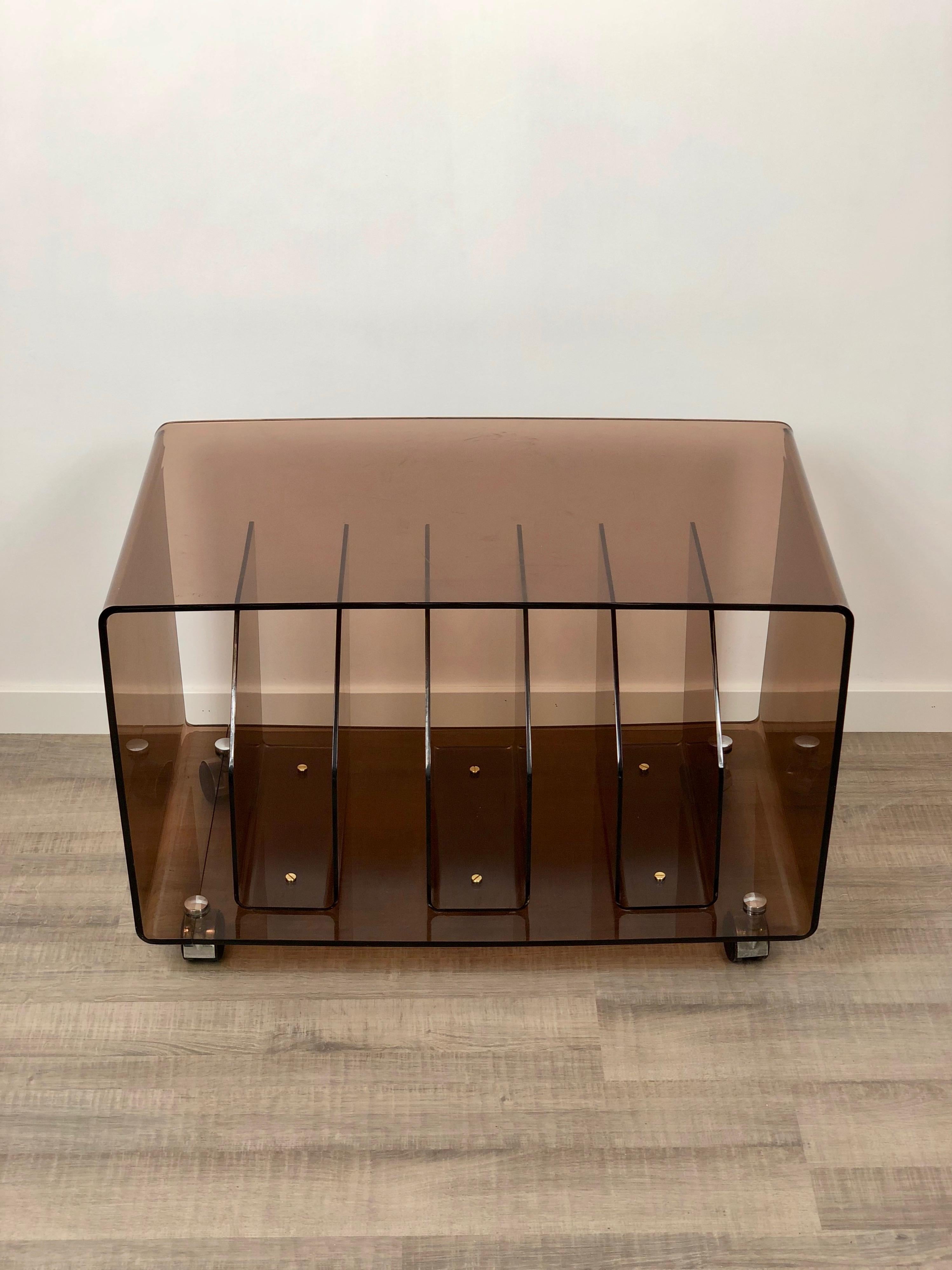Magazine vinyl racket trolley in smoked Lucite, typical item of midcentury Italian design. Made in smoked Lucite. Some scratches are visible in the lower shelf of the trolley and all of them are reported in the photos.