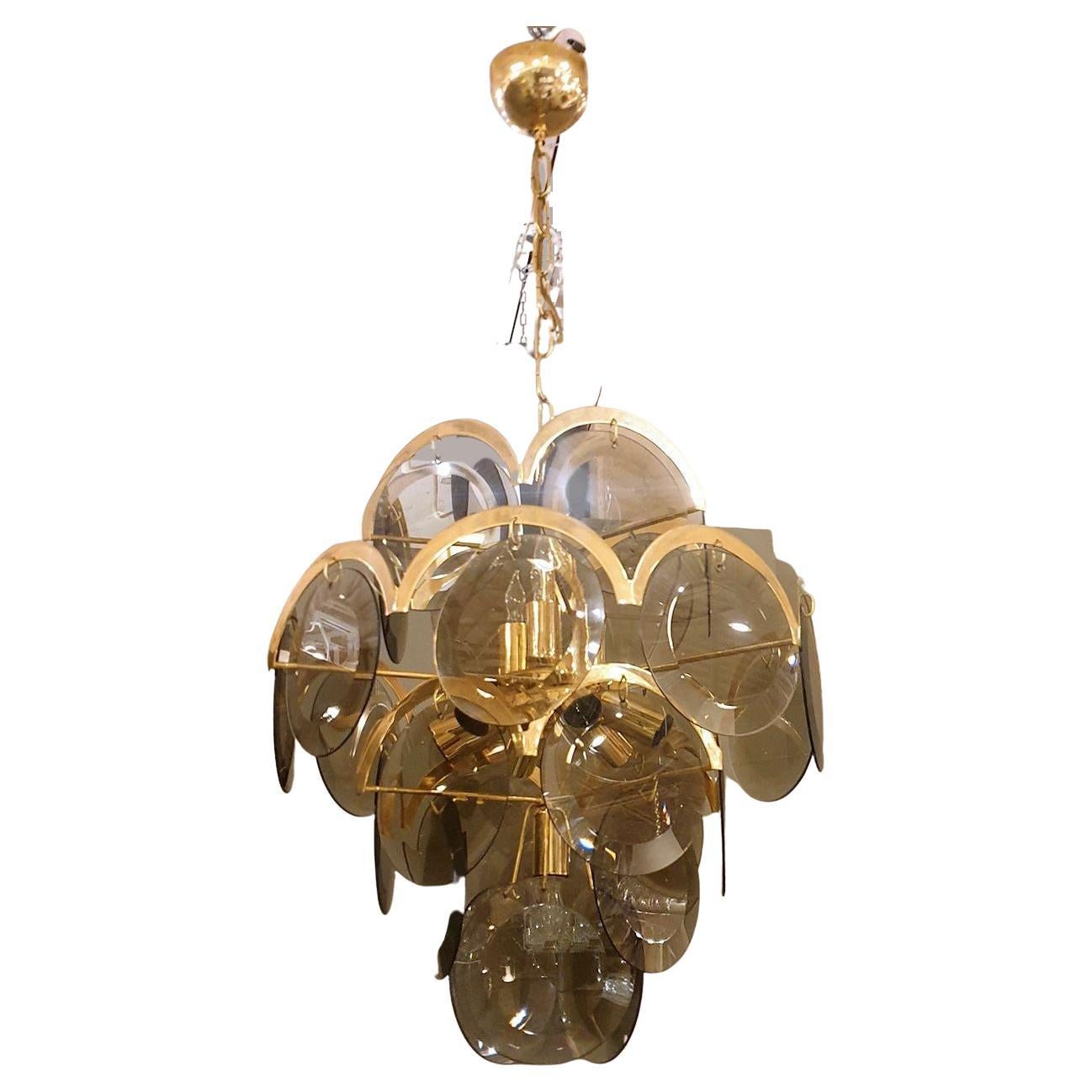 Mid-Century Modern discs Murano glass chandelier, by Vistosi Italy 1970s.
The vintage chandelier is made of smoked Murano glass discs over a brass frame.
It has 10 lights and is rewired for the US.
In very good condition.
Height of glass only: