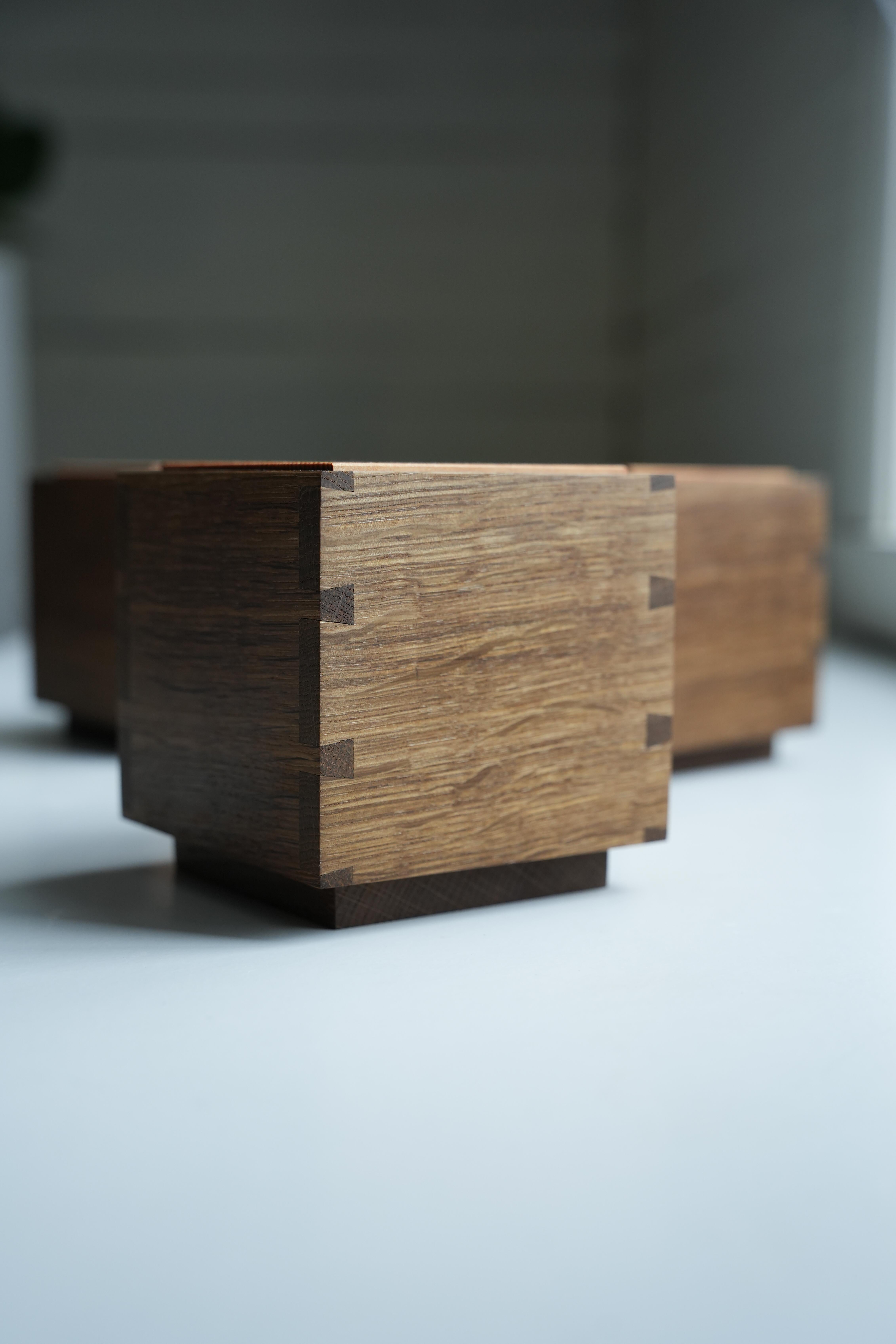 Esta caja de madera está hecha con uniones de cola de milano para mayor resistencia y precisión. La caja exterior es de roble ahumado, mientras que la interior, también hecha con uniones de cola de milano, es de abedul. La tapa es de madera maciza