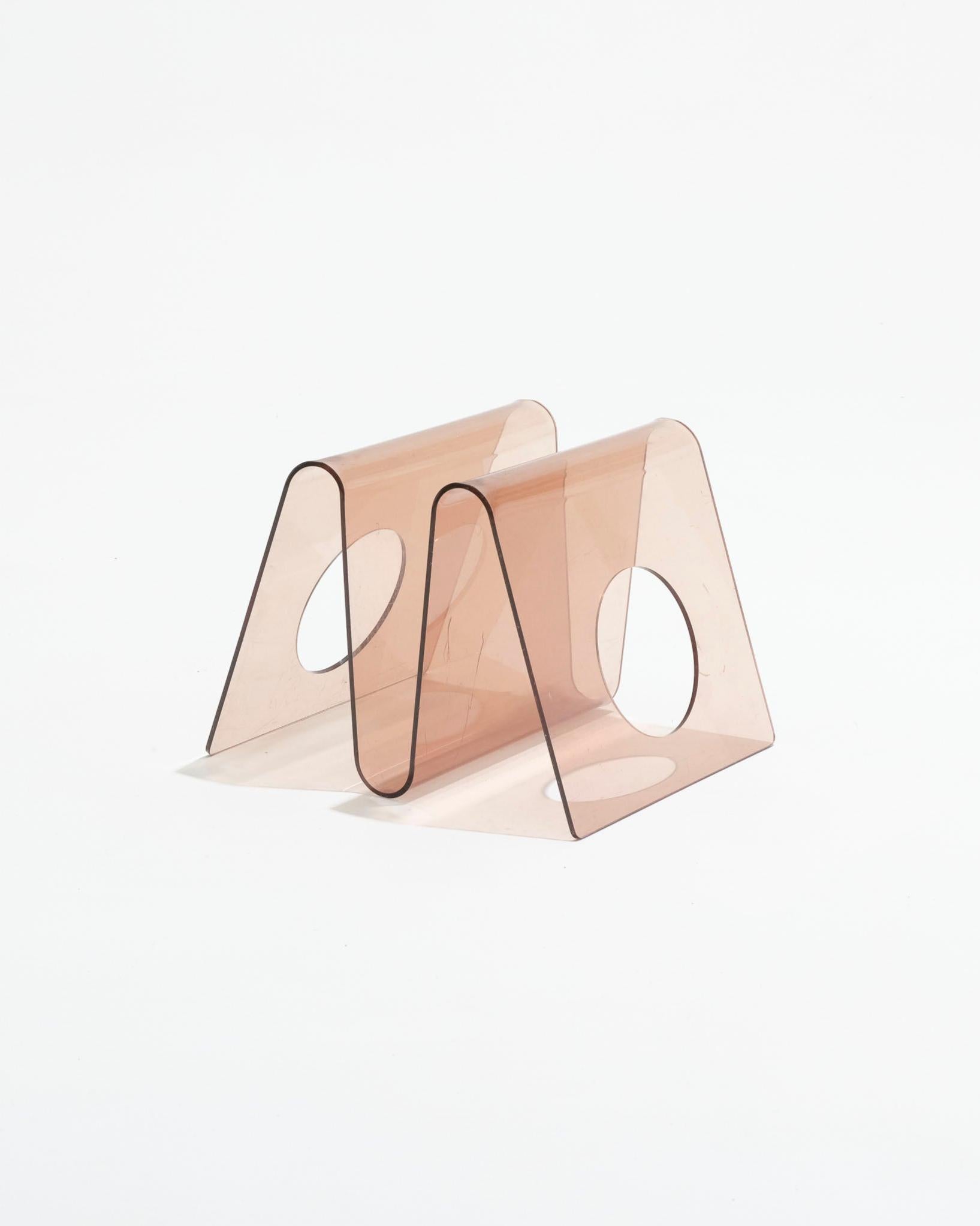 Portariviste in plexiglass disegnato da Michel Dumas e prodotto da Roche Bobois negli anni '70. Struttura a forma di Z con centro cavo. Design futuristico e giocoso, tipico dell'estetica dell'epoca. Sulla superficie sono visibili segni di utilizzo e