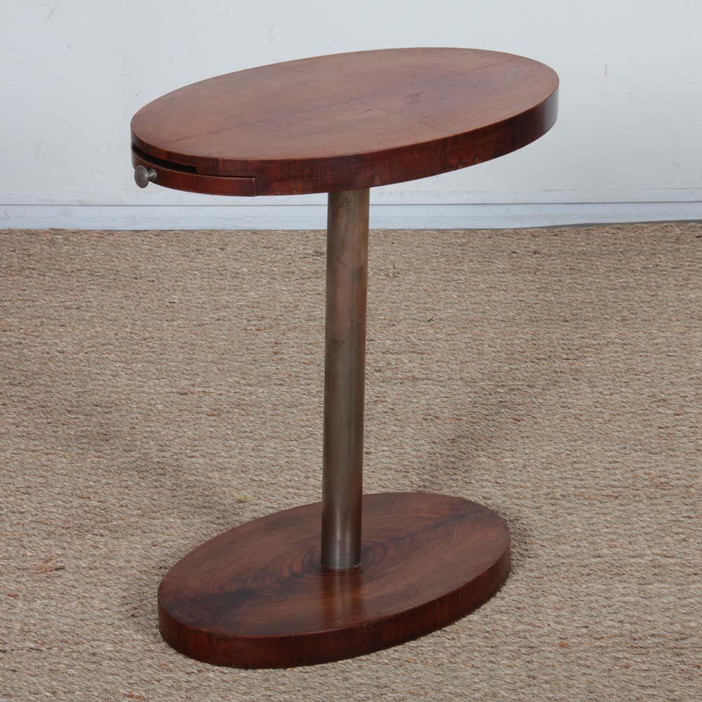 This smoker's side table is a modernist work from the 1930s. It includes a small drawer revealing an ashtray. This sofa end table is in good original condition. 

