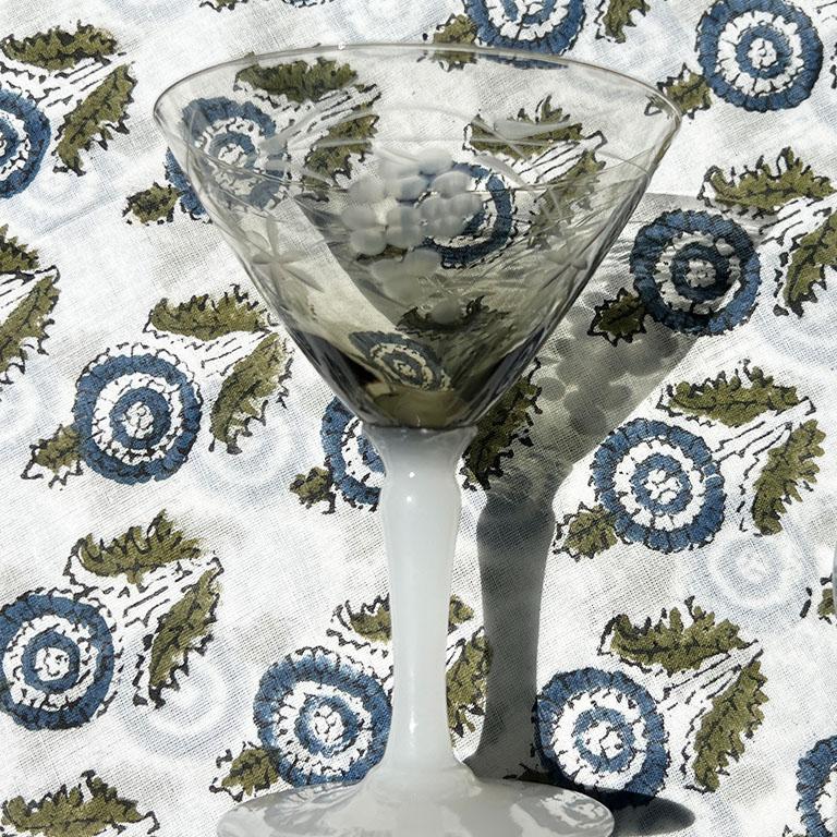 A petite pair of smokey gray etched martini glasses with milk glass round bases. This pair of glasses will be a wonderful addition to your barware. The bases are in a white glass with round bottoms. They almost look like milk glass. The tops are