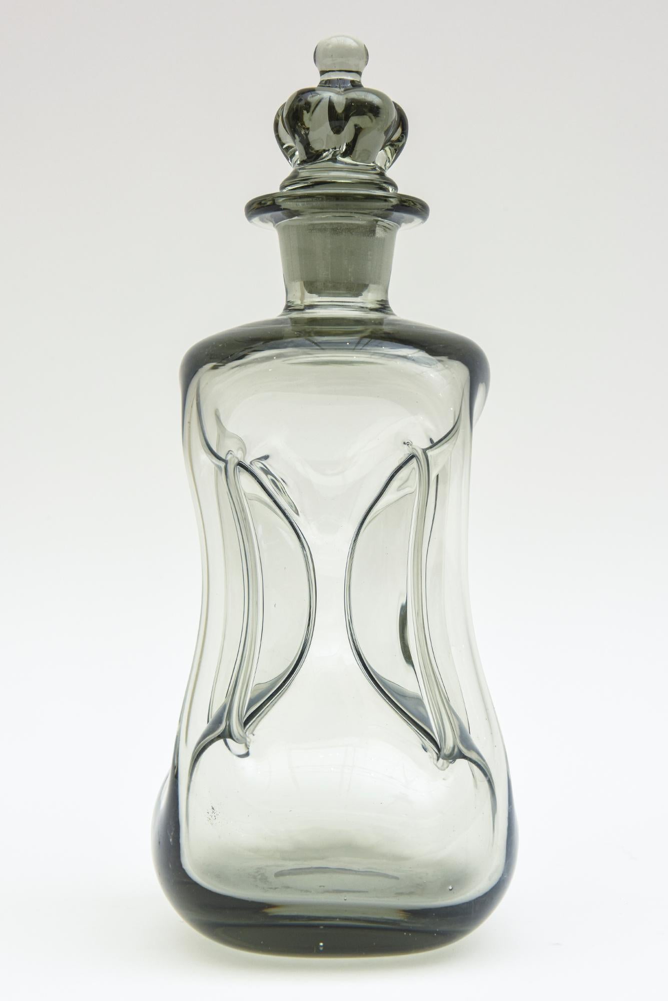 This vintage smokey gray gradient blown glass cinched decanter bottle was designed by Michael Bang for Holmegaard. It is called the Kluk Kluk. He was a major designer for the company. This is from the 1960s. What is most unusual about this is the