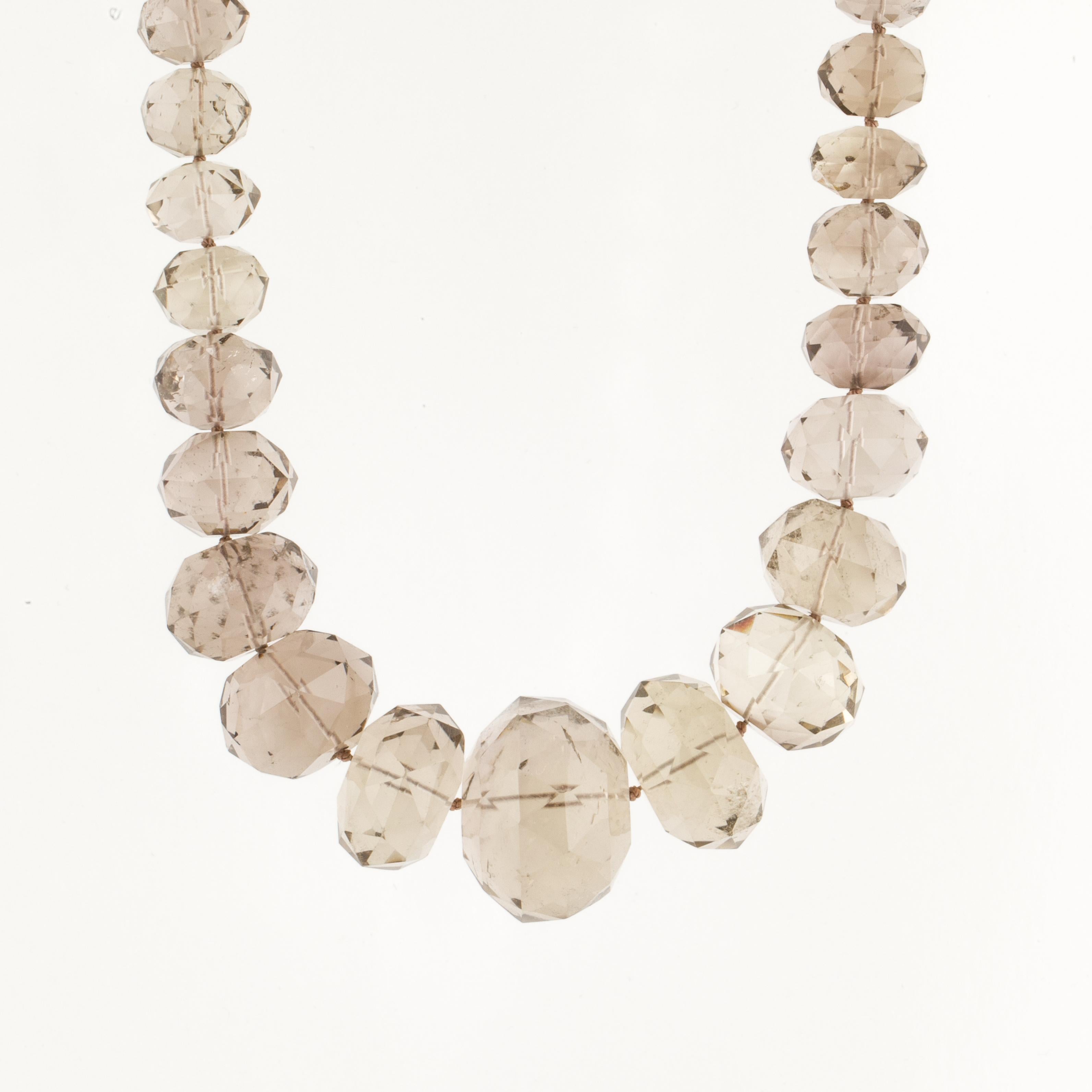 Bead necklace featuring graduated faceted smokey quartz beads and a 14K yellow gold clasp.  The necklace measures 18 1/4 inches long and the largest bead measures 1 1/8 inches across.  