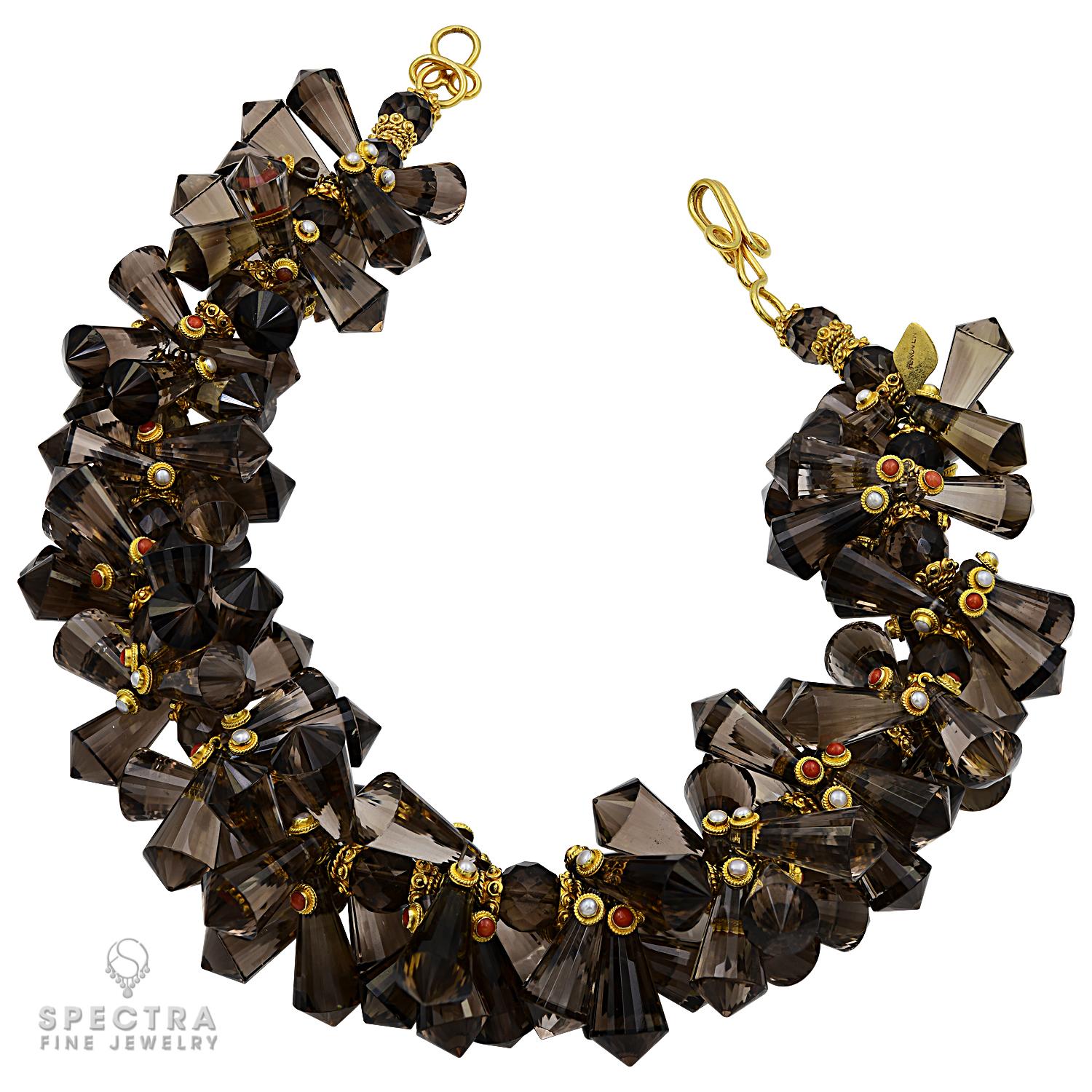 A beaded necklace made of natural smokey topaz semi-precious stone. Total weight is 999 carats. 
The necklace is accented with coral and pearl cabochons set in 22kt yellow gold. 
Weight of the necklace is 250.00 g. 
Length 16 inches (40.64cm).