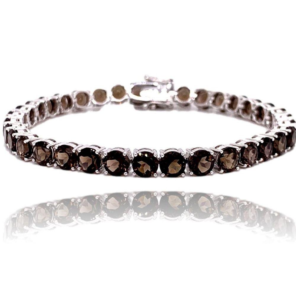 This stunning 10K White Gold Smokey Topaz Tennis Bracelet has 35  5.0mm round chocolate colored Smokey Topaz all with 4 prong setting. The bracelet is 7