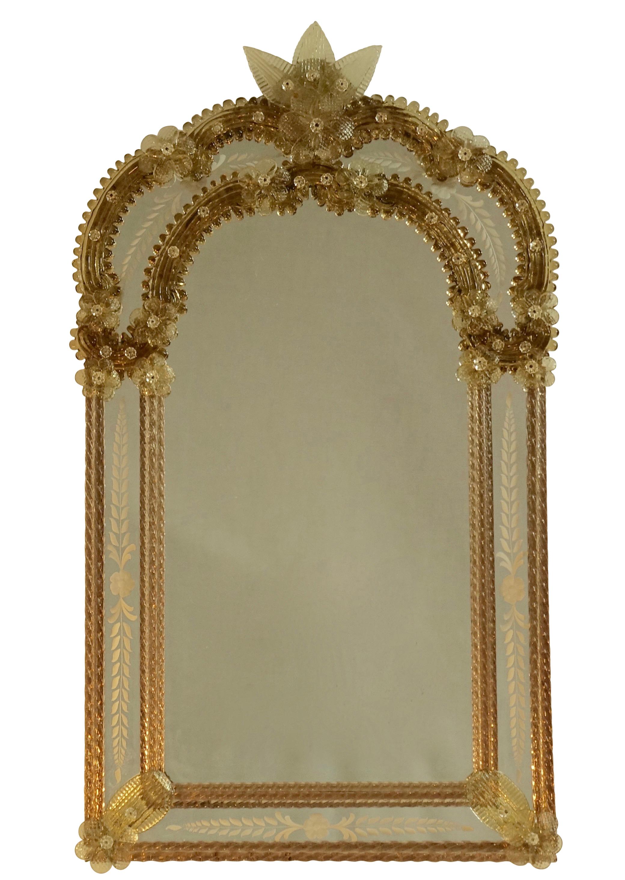 Arched shape top Venetian mirror with smokey topaz colored glass, adorned with glass florets and leaves, and having an etched design in the glass panels. Italian, circa 1950.