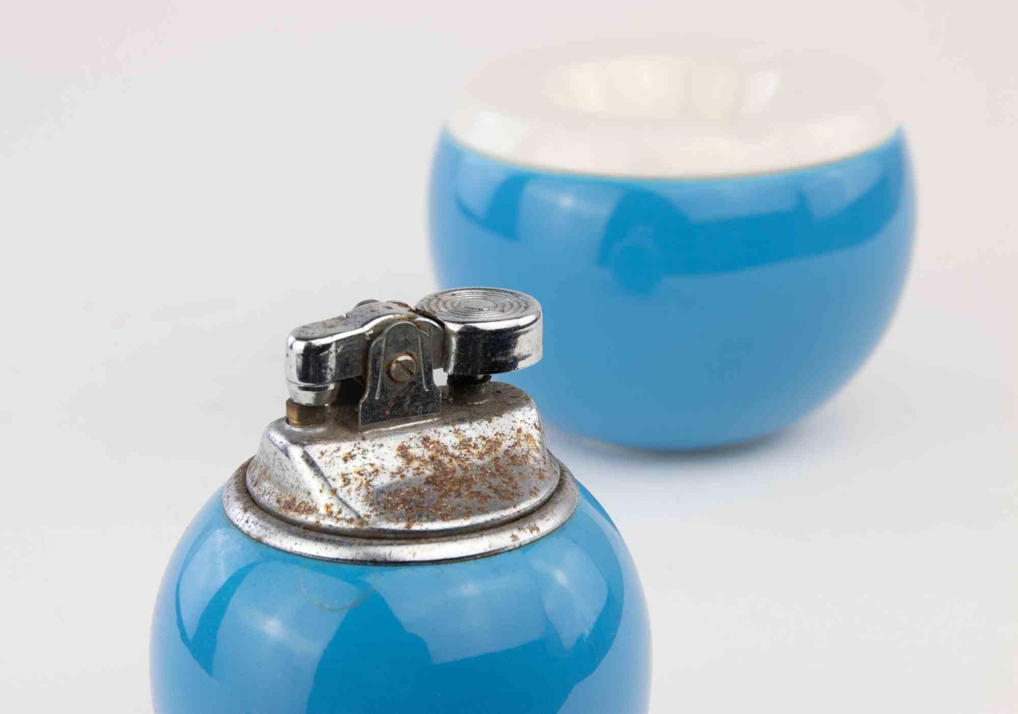 Smoking Set is a  decorative object realized in the 1970s.

A ceramic blue colored smoking set composed by a lighter and an ashtray.

Dimensions:

Lighter: h.7.5 x 7 cm

Ashtray: h. 7 x 9.5 cm