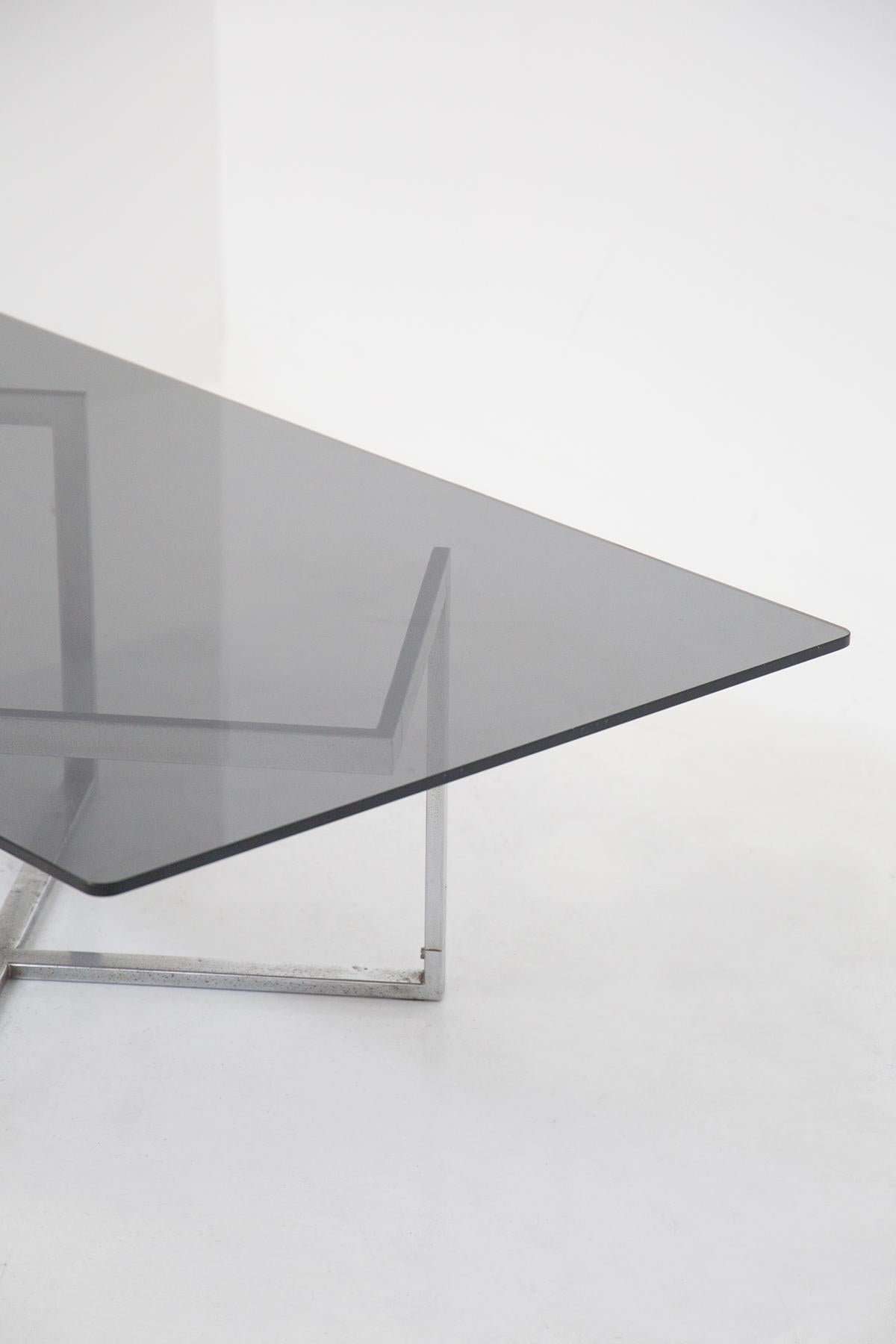 Merveilleuse table de fumeur en verre et acier conçue par Vittorio Introini dans les années 70, provenant de la résidence de Vip.
La table a une forme rectangulaire avec des lignes dures et classiques.
Le plateau est réalisé en verre fumé très
