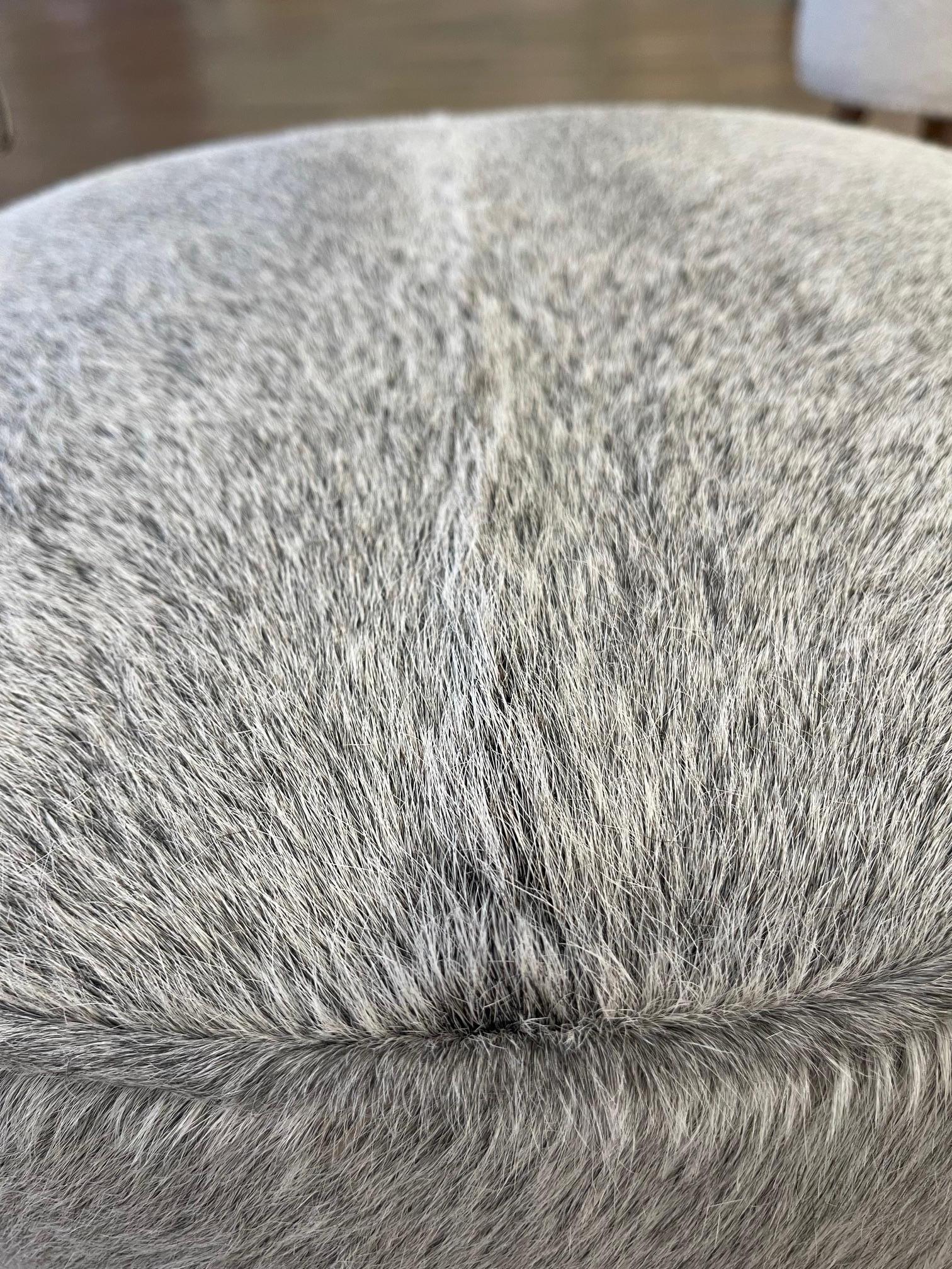 Questa versione del pouf è avvolta in una pelle di vitello piumata grigio fumo.  Il grigio e il bianco con accenti di nero gli conferiscono un aspetto di cenere e carbone difficile da trovare. È ottimo come pezzo d'accento. Perfetto per il comfort e